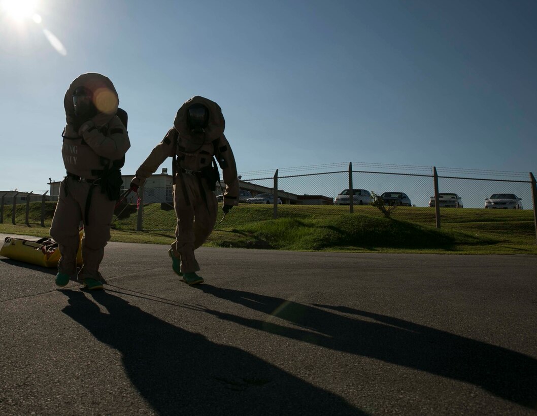 Cpl. Jon R. Loftis, left, and Lance Cpl. Wendell Albury pull a simulated casualty to a decontamination area during an assessment and consequence management response training event Aug. 27 at Marine Corps Air Station Futenma. The casualties were brought to a decontamination area where they were cut out of their clothes, cleaned and transported to a medical treatment facility. Loftis is from Maple Lake, Minnesota, and Albury is from Tampa, Florida. Both are chemical, biological, radiological and nuclear defense specialists with Marine Wing Headquarters Squadron 1, 1st Marine Aircraft Wing, III Marine Expeditionary Force. (U.S. Marine Corps photo by Lance Cpl. Tyler Ngiraswei/Released)