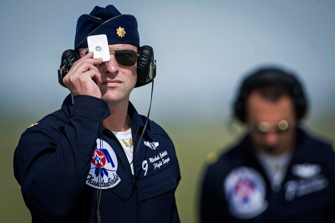 Air Force Maj. Michael Carletti, Thunderbird 9, uses an aircraft signaling mirror to assist demonstration pilots during the Wings of Freedom Open House on Altus Air Force Base, Okla., Sept. 13, 2014.