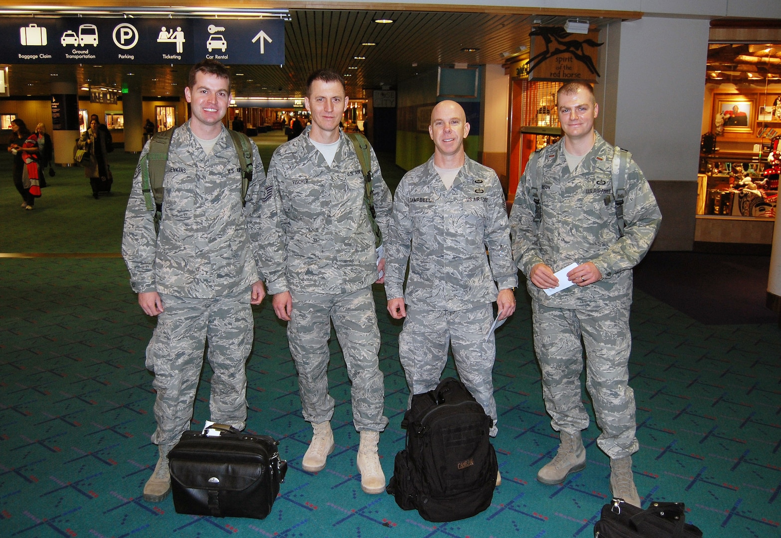 From left to right, Staff Sgt. Matt Jenkins, Tech. Sgt. Ken Michael Fischer, Master Sgt. Ken Campbell, and Lt. Mark Gibson, all members of the Oregon Air National Guard's 123rd Weather Flight, based at the Portland Air National Guard Base, in Portland, Ore., prepare to board a commercial flight bound for Port-au-Prince, Haiti, Feb. 2, 2010. The team will spend about six months providing weather operations support to the Joint Task Force in Haiti.