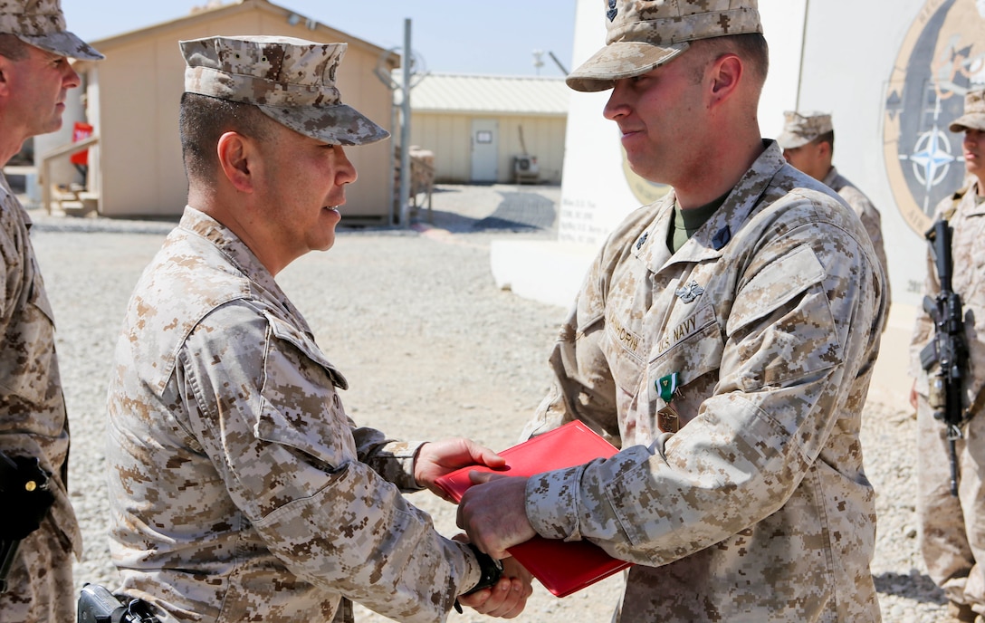 Brigadier Gen. Daniel D. Yoo, left, commander, Regional Command (Southwest) and Marine Expeditionary Brigade – Afghanistan, awards Petty Officer 2nd Class Joshua Van Horn, a corpsman with 1st Air Naval Gunfire Liaison Company, a Navy and Marine Corps Commendation Medal with Combat Distinguishing Device during an award ceremony aboard Camp Leatherneck, Afghanistan, Sept. 17, 2014. Van Horn received the award for heroic achievement while being a first responder to Marine casualties after their vehicle struck an improvised explosive device.