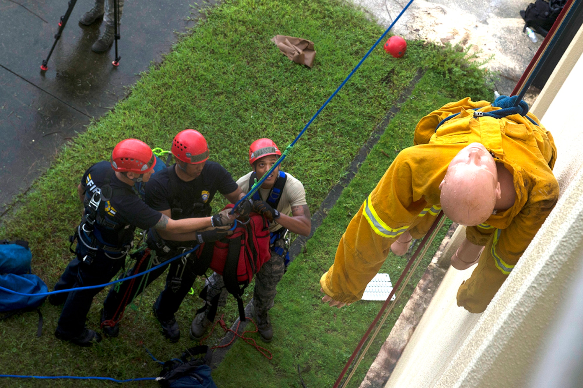 Firefighters with the 36th Civil Engineer Squadron hoist supplies to the roof of a hot spot to rescue a simulated victim during the Defense Department Rescue Technician Course Sept. 16, 2014, on Andersen Air Force Base, Guam. Thirteen firefighters from Andersen AFB, Naval Base Guam and the Guam Fire Department attended the three-week course taught by 554th RED HORSE Squadron instructors. (U.S. Air Force photo/Tech. Sgt. Zachary Wilson)