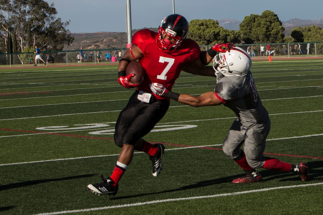 Kyle Byrdsong, running back with the Marine Corps Air Station Miramar Falcons, dodges a tackle during a game against the 11th Marines Cannon Cockers at Paige Fieldhouse aboard Marine Corps Base Camp Pendleton, Calif., Sept. 17. The Falcons defeated the Cannon Cockers 30-6. 