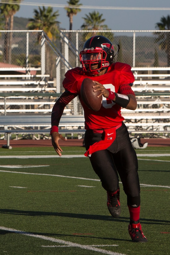 Jabari Moore, Marine Corps Air Station Miramar Falcons’ quarterback, runs the ball during a game against the 11th Marines Cannon Cockers at Paige Fieldhouse aboard Marine Corps Base Camp Pendleton, Calif., Sept. 17. This is the Falcons’ third win of the season. 