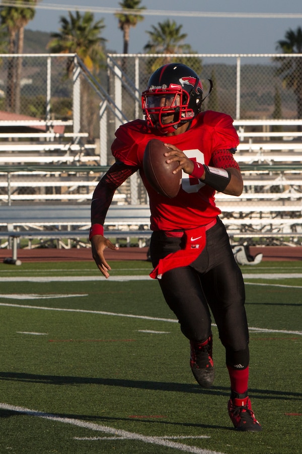 Jabari Moore, Marine Corps Air Station Miramar Falcons’ quarterback, runs the ball during a game against the 11th Marines Cannon Cockers at Paige Fieldhouse aboard Marine Corps Base Camp Pendleton, Calif., Sept. 17. This is the Falcons’ third win of the season. 