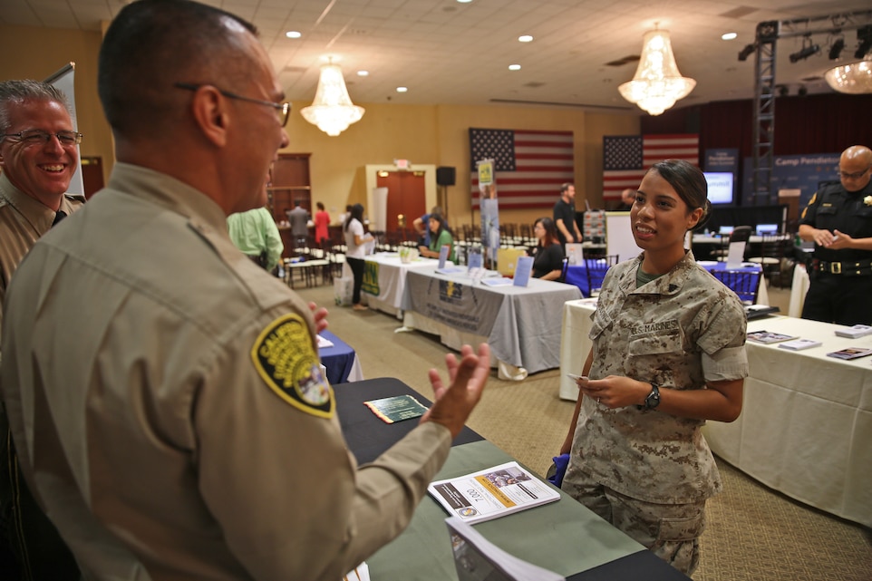 CAMP PENDLETON, Calif. - Marine Corps Base Camp Pendleton held a Hiring Our Heroes jobs summit at the Pacific Views Events Center here, Sept. 17-18, to provide service members, veterans and spouses with networking opportunities and improve their competitiveness in the workforce.Lieutenant Ray Baez, an officer with the California Department of Corrections, discusses employment opportunities with Cpl. Jennifer Rolon, an intelligence analyst during the Career Fair portion of the summit.Approximately 600 participants attended the event, which hosted 109 companies from a diverse field ranging from finance to the automotive industry. (U.S. Marine Corps photo by Cpl. Shaltiel Dominguez)