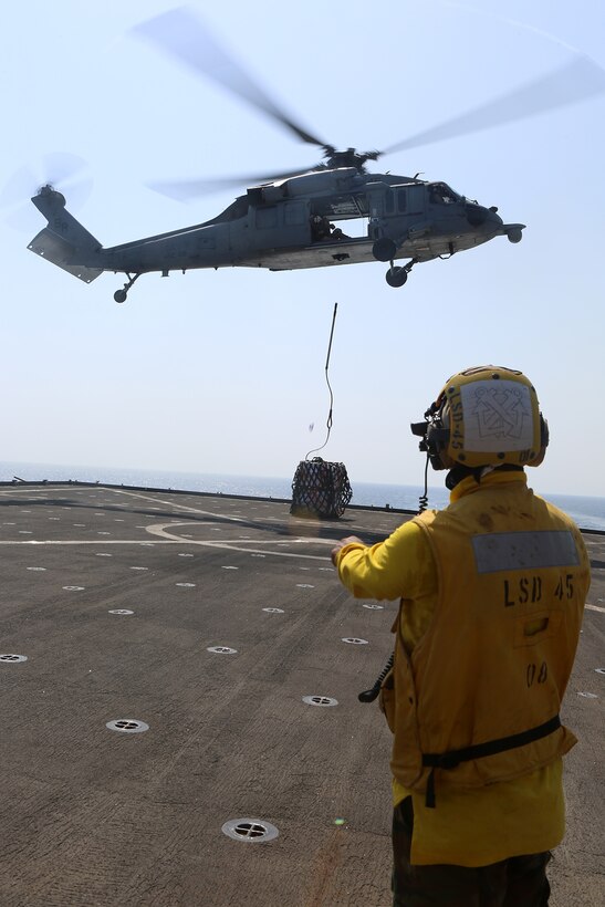 A sailor with the USS Comstock (LSD 45) directs an MH-60S Sea Hawk releasing a pallet during a replenishment at sea, Sept. 16. The Comstock is part of the Makin Island Amphibious Ready Group and, with the embarked 11th Marine Expeditionary Unit, is deployed in support of maritime and theater security operations in the U.S. 5th Fleet area of responsibility. (U.S. Marine Corps photo by Sgt. Melissa Wenger/ Released)