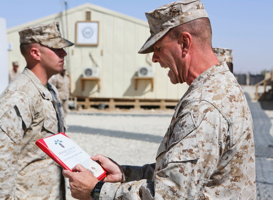Sergeant Maj. Doug Berry Jr., right, sergeant major, Regional Command (Southwest) and Marine Expeditionary Brigade – Afghanistan, reads the Navy and Marine Corps Commendation Medal with Combat Distinguishing Device citation for Petty Officer 2nd Class Joshua Van Horn, a corpsman with 1st Air Naval Gunfire Liaison Company, during an award ceremony aboard Camp Leatherneck, Afghanistan, Sept. 17, 2014. Van Horn received the award for heroic achievement while being a first responder to Marine casualties after their vehicle struck an improvised explosive device.