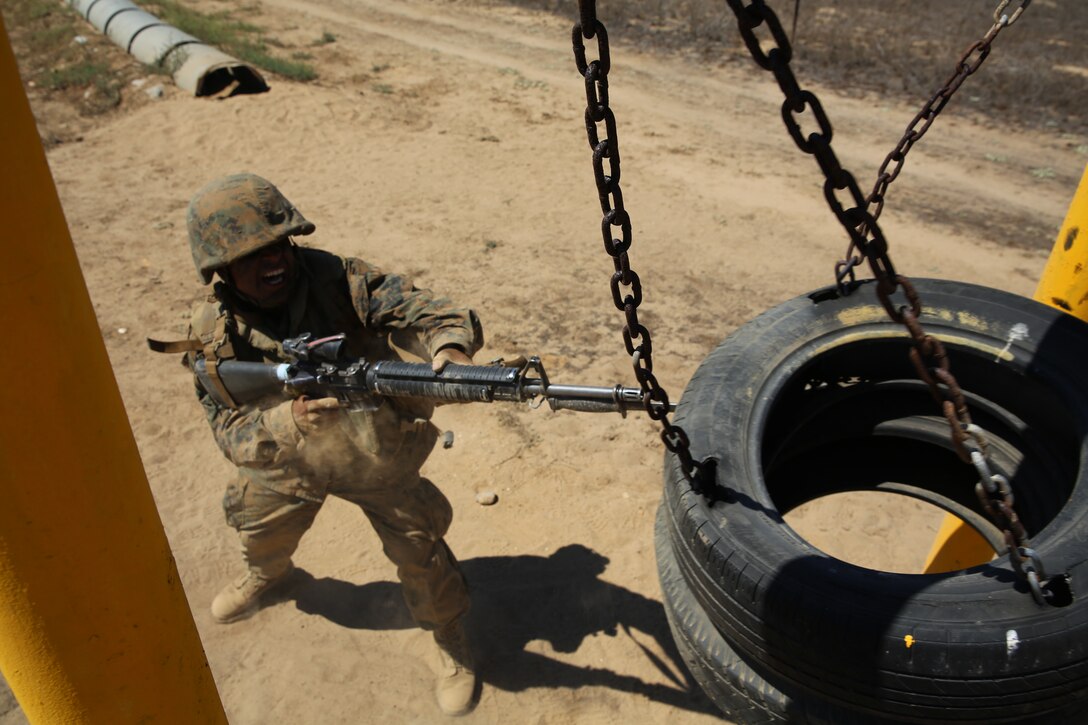 Private Alfonso A. Medinaarellano, Platoon 3223, Kilo Company, 3rd Recruit Training Battalion, applies bayonet techniques to rubber tires during the bayonet assault course as part of the Crucible at Edson Range, Marine Corps Base Camp Pendleton, Calif. Sept 11. Over the past three months, recruits learned different bayonet techniques during Marine Corps Martial Arts Program training.