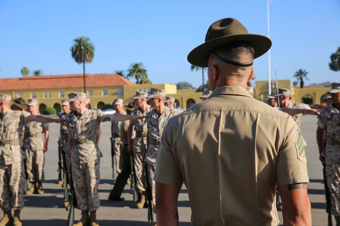 Sgt. Cesar D. Martinez, senior drill instructor, Platoon 1041, Charlie Company, 1st Recruit Training Battalion, positions his recruits to begin receiving drill commands during Final Drill at Marine Corps Recruit Depot San Diego, Calif., Sept. 15. Each company in the battalion was required to perform various drill movements that were evaluated for score.