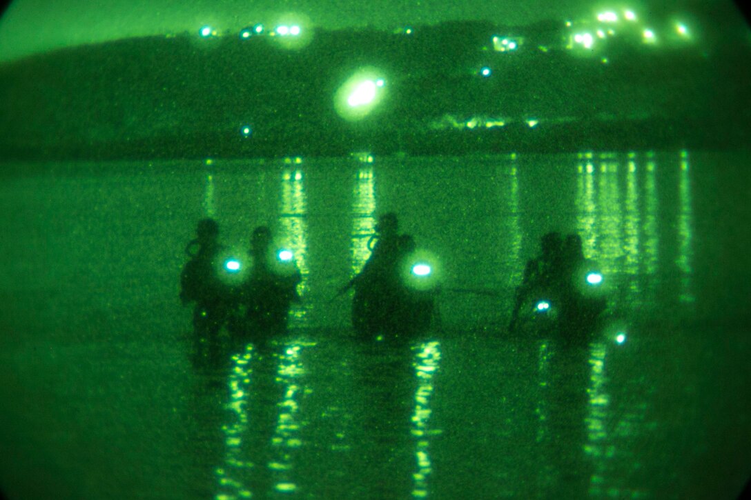 Marines wade into the ocean water Sept. 17 at U.S. Naval Base, Guam during night infiltration training as a part of Exercise Valiant Shield 2014. Valiant Shield is a U.S.-only, biennial exercise which focuses on the integration of joint training among participating forces. During the training, Marines swam ashore from Combat Rubber Raiding Crafts, secured the beach and swam back out to the CRRCs. The Marines are reconnaissance men with 3rd Reconnaissance Battalion, 3rd Marine Division, III Marine Expeditionary Force. (U.S. Marine Corps photo by Cpl. Lena Wakayama/Released)