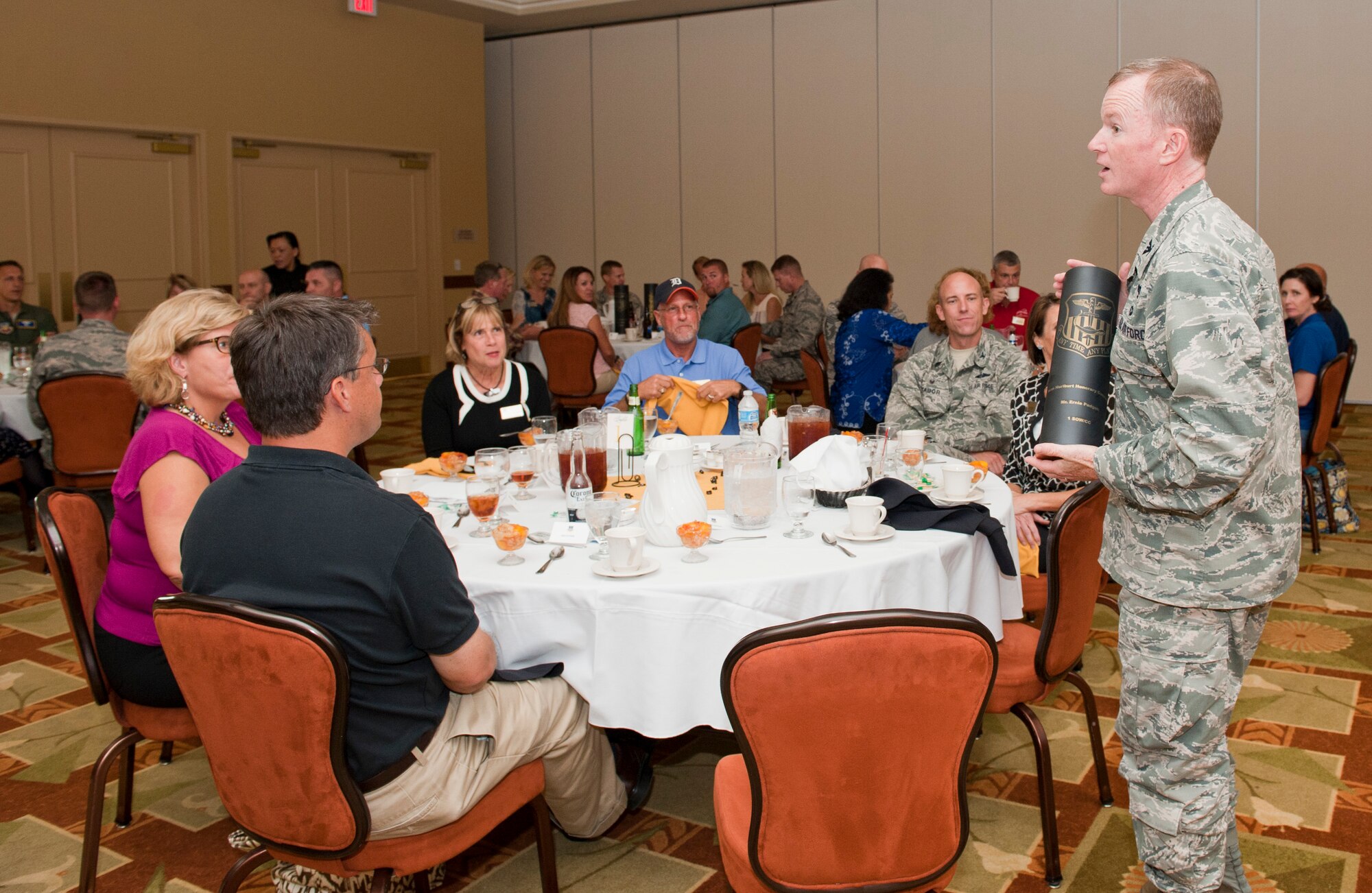 Col. Bill West, 1st Special Operations Wing commander, presents the outgoing 1 SOW Honorary Commander with a gift during an Honorary Commanders banquet at the Soundside Club on Hurlburt Field, Fla., Sept. 19, 2014. Outgoing Honorary Commanders received an engraved .105 shell, and the new commanders received a coin from their unit counterparts. (U.S. Air Force photo/Senior Airman Krystal M. Garrett)
