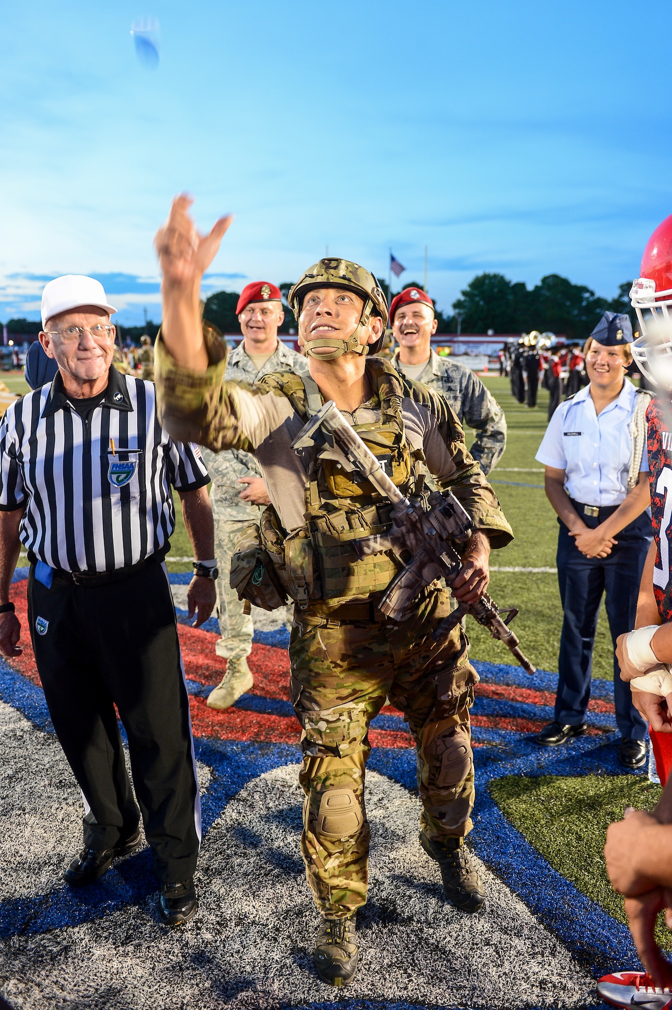 Tech. Sgt Ismael Villegas, 24th Special Operations Wing, Special Tactics Training Squadron special tactics member, flips the game coin at Fort Walton Beach High School, Fort Walton Beach, Fla., Sept. 12, 2014. F W B High School hosted a military appreciation night, to pay tribute to their local servicemen and women.  (U.S. Air Force photo/Airman 1st Class Jeff Parkinson)