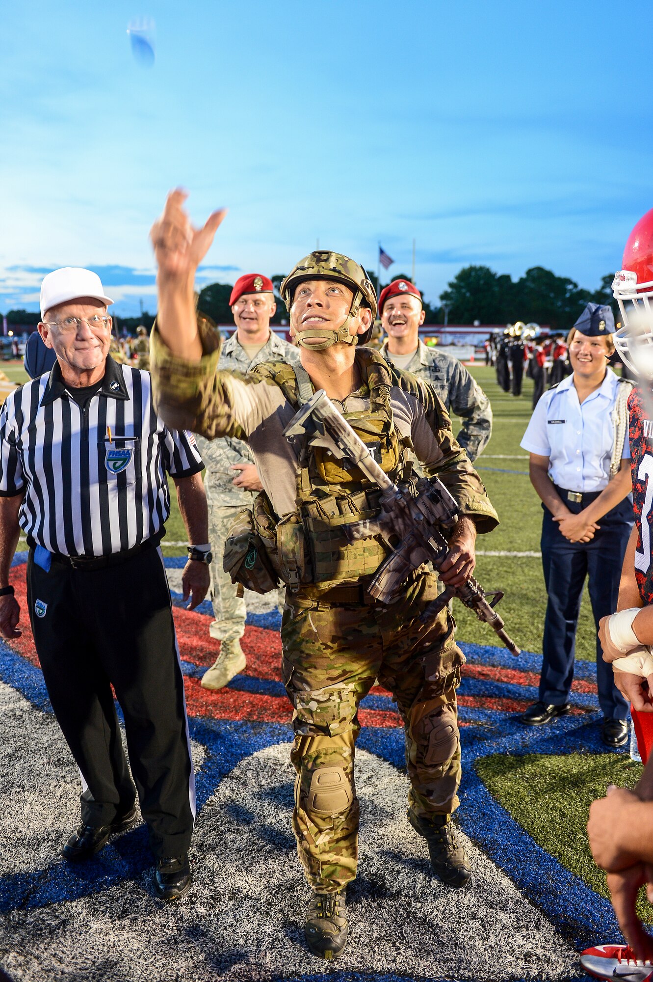 Tech. Sgt Ismael Villegas, 24th Special Operations Wing, Special Tactics Training Squadron special tactics member, flips the game coin at Fort Walton Beach High School, Fort Walton Beach, Fla., Sept. 12, 2014. F W B High School hosted a military appreciation night, to pay tribute to their local servicemen and women.  (U.S. Air Force photo/Airman 1st Class Jeff Parkinson)