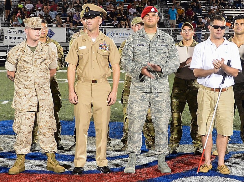 Wounded Warriors, from left or right, Marine Cpl. retired Keith Jackson,  Navy Senior Chief EOD William J Bishop,  Air Force Senior Airman Edward Newbern and  Army Staff Sgt. retired Aaron Hale, were recognized during the half-time show at Fort Walton Beach High School, Fort Walton Beach, Fla., Sept. 12, 2014. F W B High School held a military appreciation night to honor local military members and its wounded warriors. (U.S. Air Force photo/Airman 1st Class Jeff Parkinson)