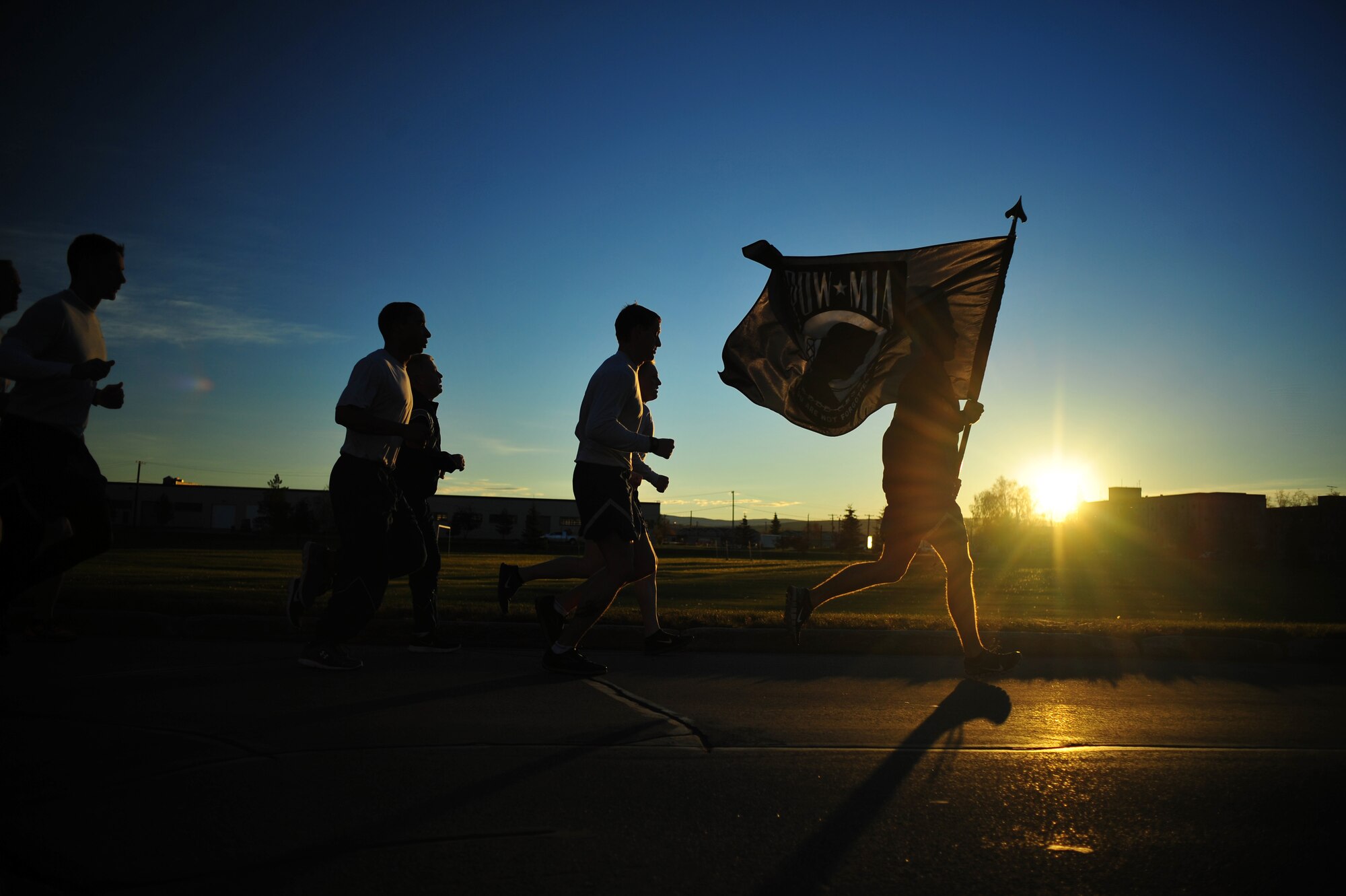 Members of Det. 1, 3rd Air Support Operations Squadron run during a Prisoner of War/Missing in Action 24-hour vigil e run Sept. 19, 2014, Eielson Air Force Base, Alaska. The POW/MIA flag is a symbol of citizen concern about U.S. military personnel taken as prisoners of war or listed as missing in action. (U.S. Air Force photo by Staff Sgt. Jim Araos /Released)