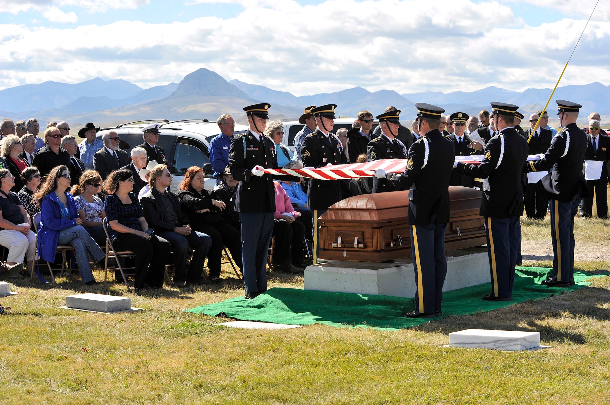 Soldiers from the Montana Army National Guard honor guard elevate an American flag over the casket containing Army Air Forces 1st Lt. William D. Bernier Sept. 19 at Augusta Cemetery, Mont. Bernier was killed in action over New Guinea during WWII, and his remains were positively identified earlier this year. (Air Force photo/John Turner)
