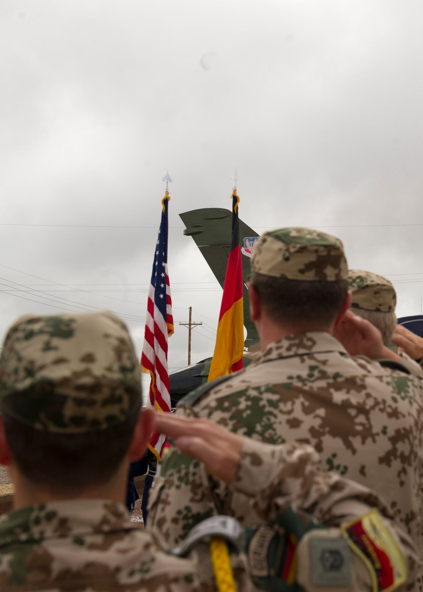 German Air Force members salute during the playing of both the German and United States National anthems. History was made Sep. 19, when a German Air Force static aircraft was unveiled in Heritage Park by Lt. Gen. Martin Schellis, German Air Force Operational Forces Command commander, and Col. Robert Kiebler, 49th Wing commander. The GAF Training Center and the Tornados are a significant part of military aviation operations in and around Holloman Air Force Base and White Sands Missile Range. (U.S. photo by Staff Sgt. E’Lysia Wray/ Released) 
