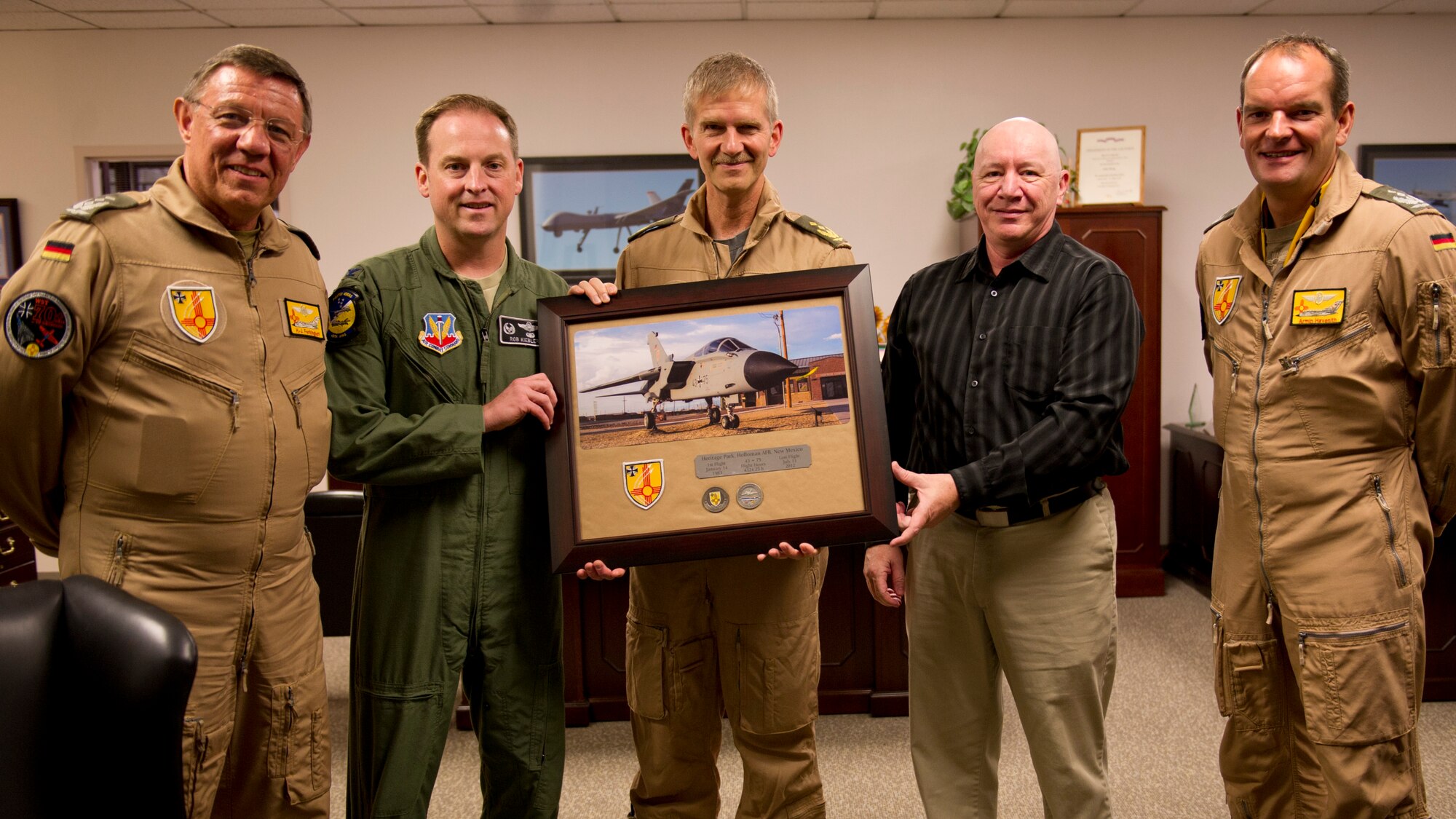 Colonel Robert Kiebler, 49th Wing commander and James Burrett, Wing historian, are presented with a plaque from Lt. Gen. Martin Schellis, German Air Force Operational Forces Command commander, Col. Heinz Ferkinghoff, German Air Force Flying Training Center commander, and Col. Armin Havenith, GAF FTC vice commander. History was made Sep. 19, when a German Air Force static aircraft was unveiled in Heritage Park by Schellis and Kiebler. The GAF Training Center and the Tornados are a significant part of military aviation operations in and around Holloman Air Force Base and White Sands Missile Range. (U.S. photo by Staff Sgt. E’Lysia Wray/ Released)