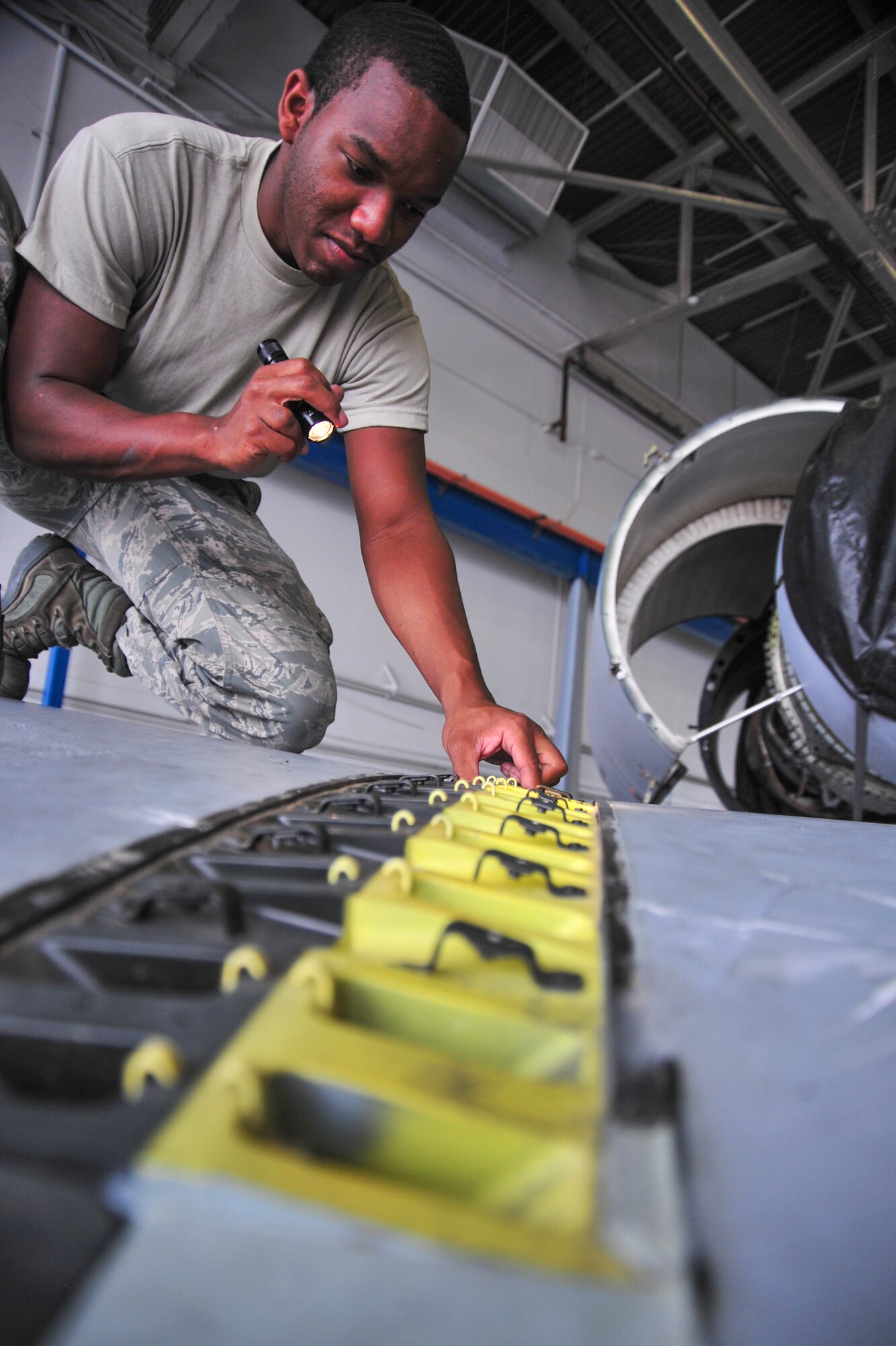 U.S. Air Force Senior Airman Antwaun Toms, 355th Equipment Maintenance Squadron electrical environmental specialist, inspects wing splices and bolts on an A-10C Thunderbolt II at Davis-Monthan Air Force Base, Ariz., Sept. 16, 2014.  During the inspection, Toms searched for foreign objects and cracks that could impact the integrity of the wing splice.  (U.S. Air Force Photo by Airman 1st Class Chris Massey/Released)