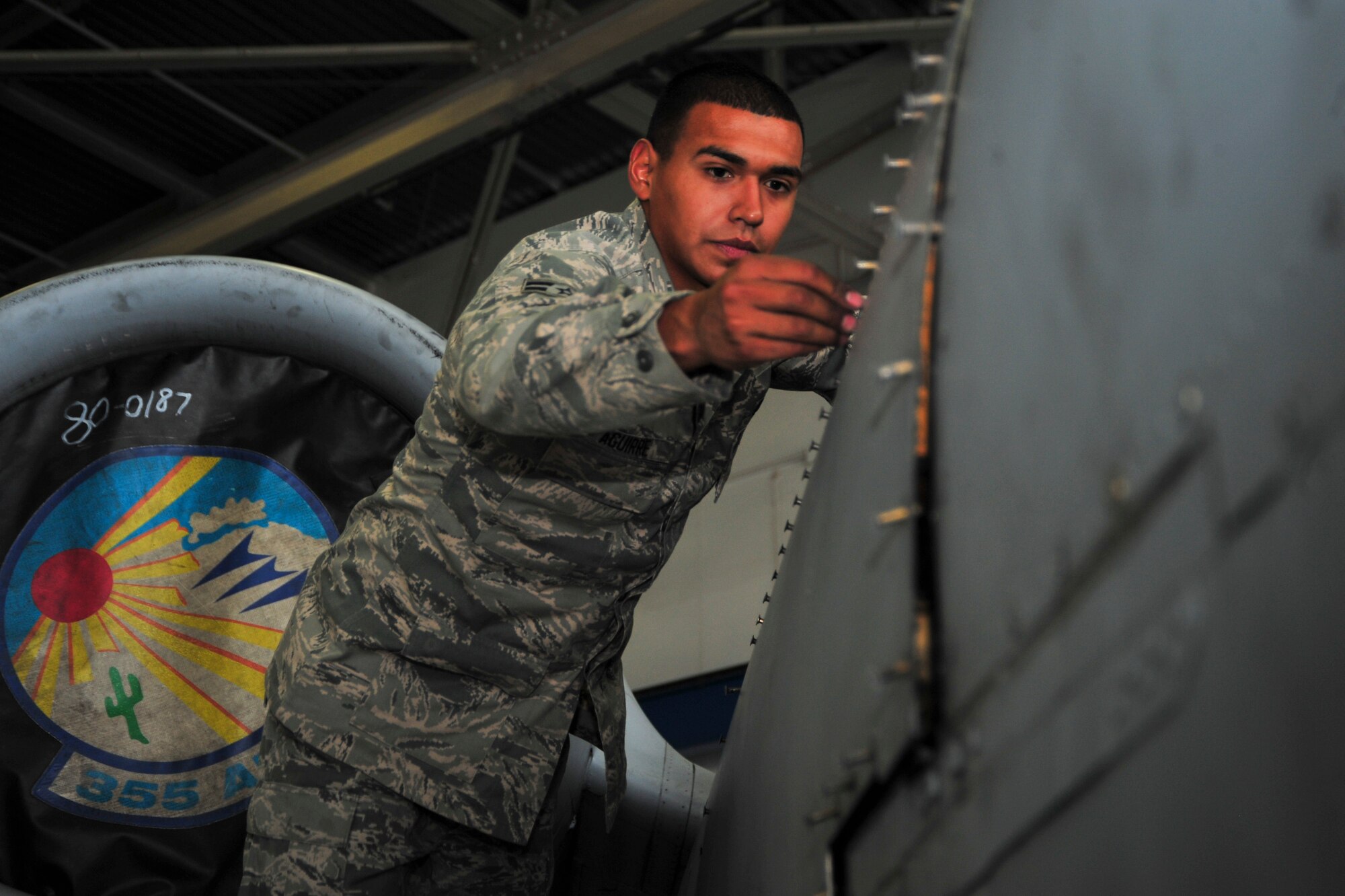 U.S. Air Force Airman 1st Class Jesse Aguirre, 355th Equipment Maintenance Squadron crew chief, inserts tridair fasteners to install a repaired panel on an A-10C Thunderbolt II during a phase inspection at Davis-Monthan Air Force Base, Ariz., Sept. 16, 2014.  Throughout the inspections, 355th EMS maintainers give the A-10 a complete in-depth inspection, looking for foreign object debris, damage, cracked or worn parts, and also ensure that every section of the airframe is intact with each piece in its proper place. (U.S. Air Force Photo by Airman 1st Class Chris Massey/Released)