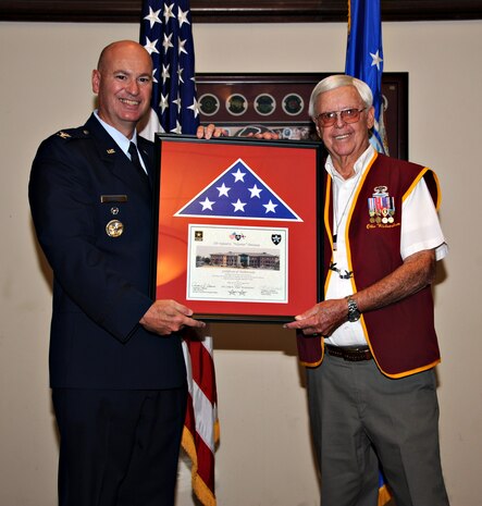 Col. Quinn A. Gummel (left), 9th Reconnaissance Wing vice commander, presents Obie Wickersham, World War II veteran and Korean War POW, with a flag from the current commander of the 2nd Infantry Division during a POW/MIA remembrance Sept. 19, 2014, at Beale Air Force Base, Calif. Wickersham, a highly-decorated soldier, served with the U.S. Army's 82nd Airborne Division during World War II and the 2nd Infantry Division in Korea. (U.S. Air Force photo by Airman 1st Class Ramon A. Adelan/Released)