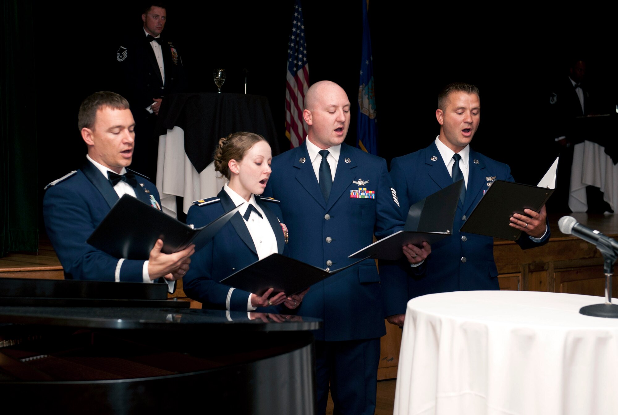 From left, Capt. Jason Parsons, Maj. Sarah Ford, Tech. Sgt. Jeff Achuff and Senior Airman James Baumgartner, all members of the 8th Space Warning Squadron singing group, perform at the Senior NCO Induction Ceremony Aug. 22, 2014, at the Heritage Eagle Bend Golf Club in Aurora, Colo. The group comprises 8th Space Warning Squadron members who perform the national anthem and other songs for military events and ceremonies. (U.S. Air Force photo by Airman 1st Class Samantha Saulsbury/Released)