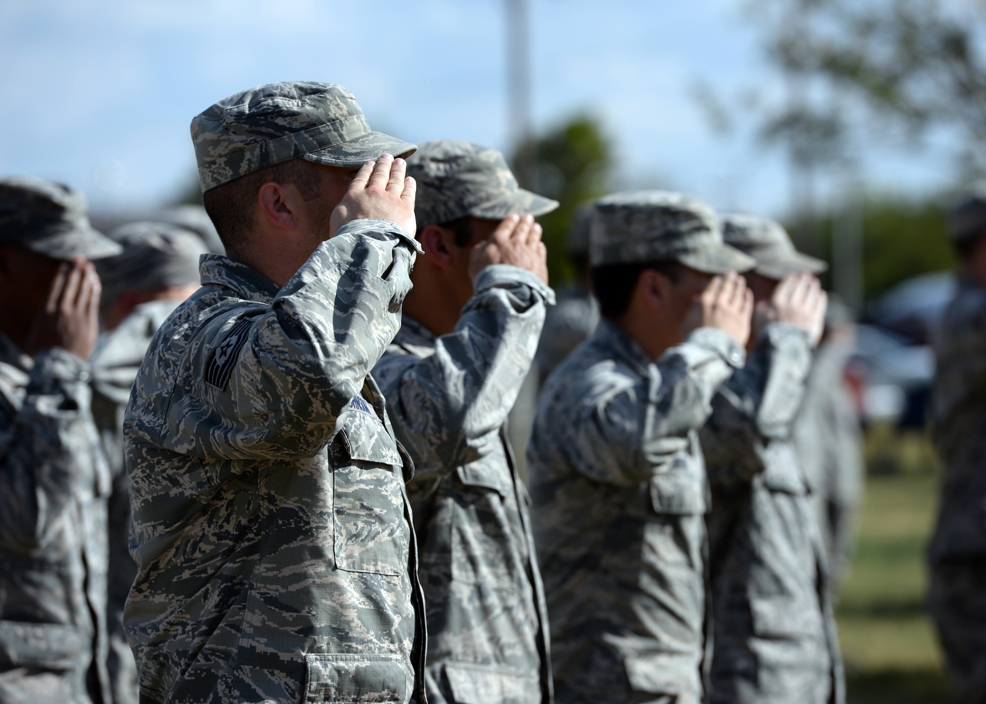 ALTUS AIR FORCE BASE, Okla. – Members of the 97th Air Mobility Wing salute as the U.S. flag is lowered during a Prisoners of War/Missing in Action Recognition Day retreat ceremony at the Wings of Freedom Park, Sept. 19, 2014. The 97th Mission Support Group hosted the ceremony and Airmen from around the base attended the remembrance ceremony. The local Air Force Sergeants Association Chapter 988 donated the ceremonial wreaths for the event. (U.S. Air Force photo by Senior Airman Franklin R. Ramos/Released)