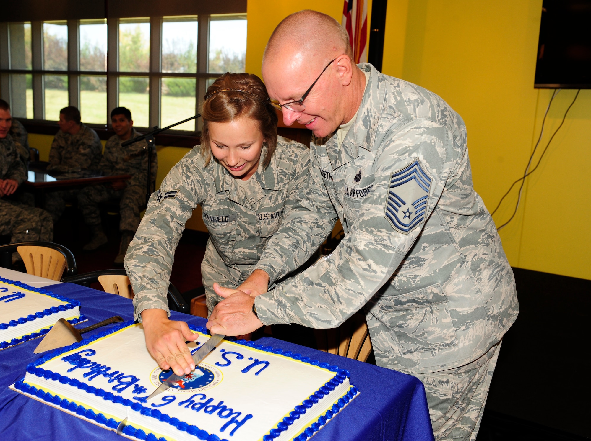 Airman 1st Class Tylar Stanfield, 460th Contracting Flight contracting specialist, left,and Chief Master Sgt. Richard Halseth, Aerospace Data Facility-Colorado senior enlisted leader, cut the cake during Team Buckley’s 67th Air Force Birthday celebration Sept. 18, 2014, at Panther’s Den on Buckley Air Force Base, Colo. Stanfield and Halseth were the Airmen with the least and most time in service, respectively, at the celebration. (U.S. Air Force photo by Airman 1st Class Samantha Saulsbury/Released)