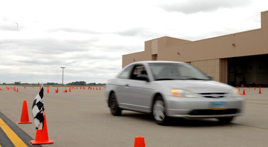 A racer crosses the finish line at the Autocross event held Sept. 14, 2014, at the free zone in front of the 3-Bay Hangar here. Nearly 60 entrants driving cars of every make and model participated in the day-long event, with proceeds going to benefit the Wounded Warrior Project. (U.S. Air Force photo/Staff Sgt. Susan L. Davis)