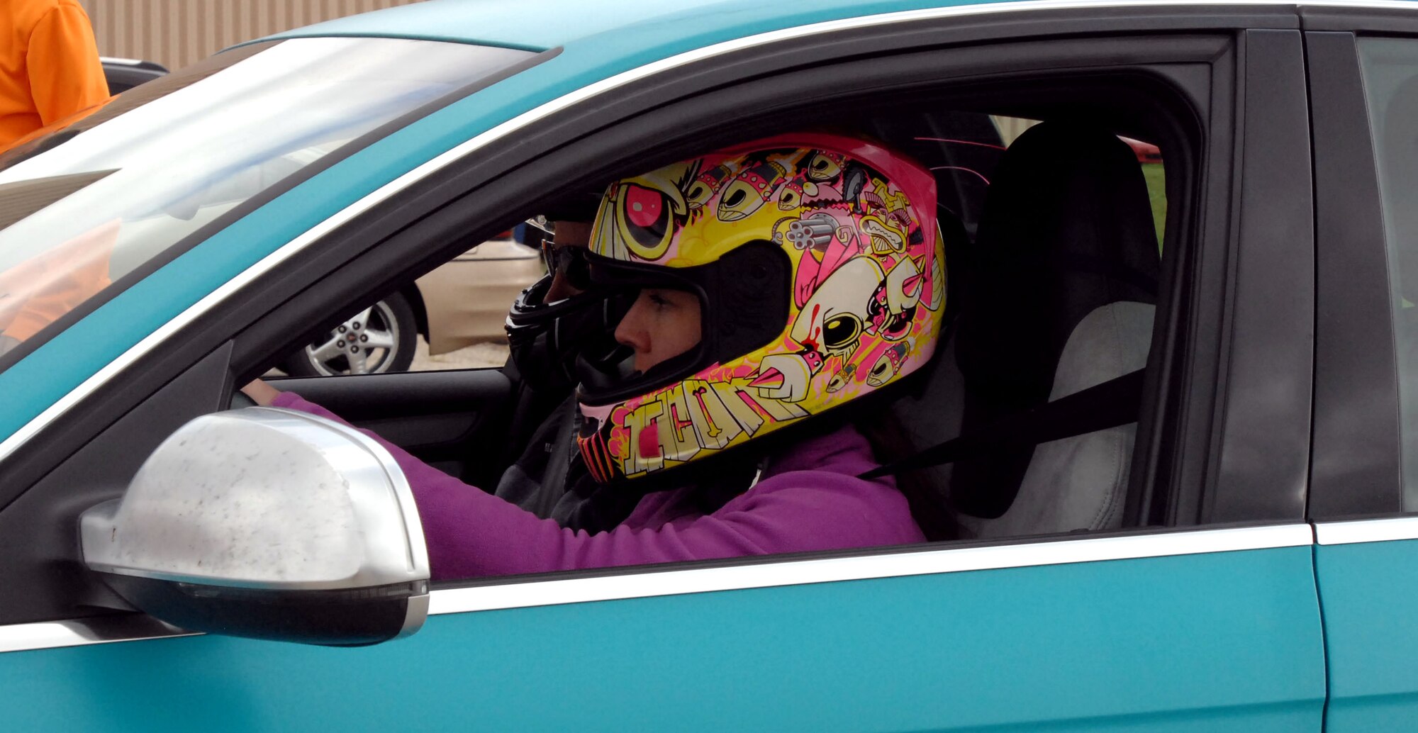 Tech. Sgt. Mindy Tyson, 319th Force Support Squadron, and Chief Master Sgt. David Duncan, 319th Air Base Wing command chief master sergeant, prepare to take on the racing course at the Autocross event held Sept. 14, 2014, at the free zone in front of the 3-Bay Hangar here. Nearly 60 entrants driving cars of every make and model participated in the day-long event, with proceeds going to benefit the Wounded Warrior Project. (U.S. Air Force photo/Staff Sgt. Susan L. Davis)