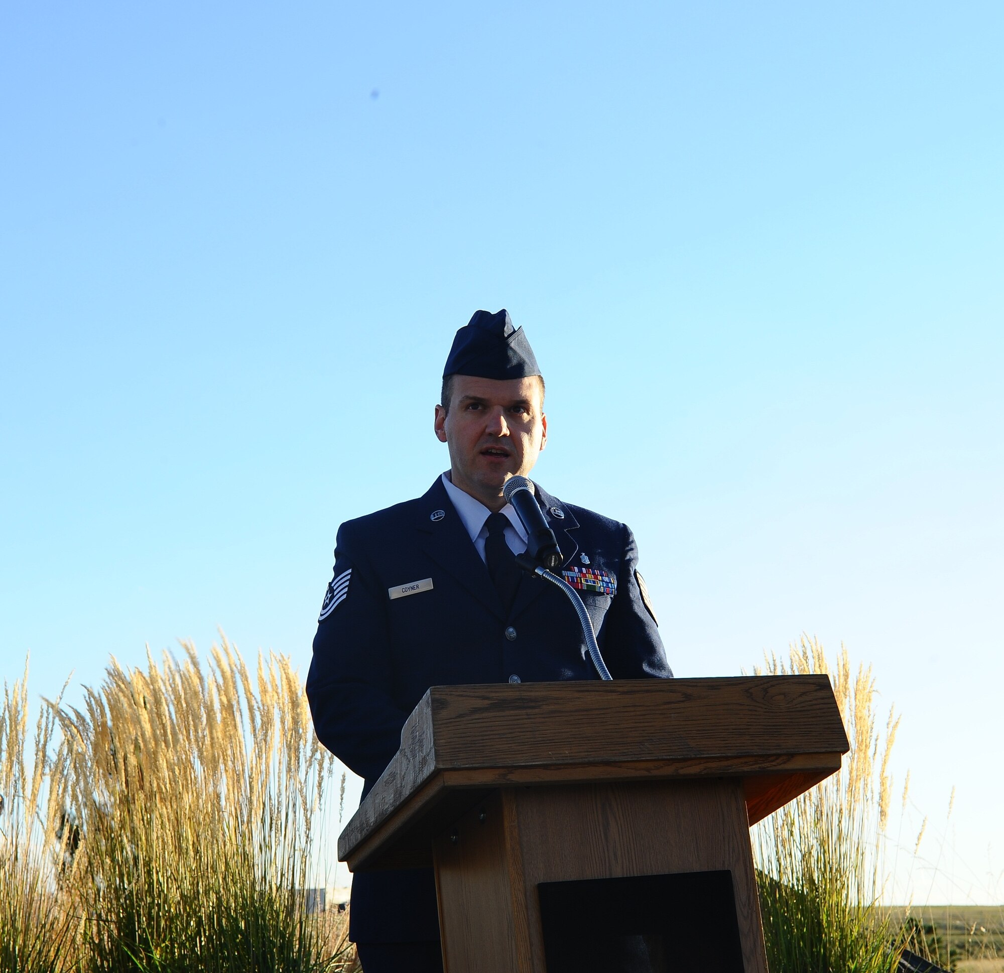 Tech. Sgt. Zach Coyner, 460th Medical Group non-commissioned officer in charge of physical therapy, speaks to Team Buckley members during the POW/MIA reveille ceremony Sept. 19, 2014, at the 460th Space Wing headquarters building on Buckley Air Force Base, Colo. The observance was held in honor of those who suffered as prisoners of war or are missing in action. (U.S. Air Force photo by Tech. Sgt. Rob Hazelett/Released)