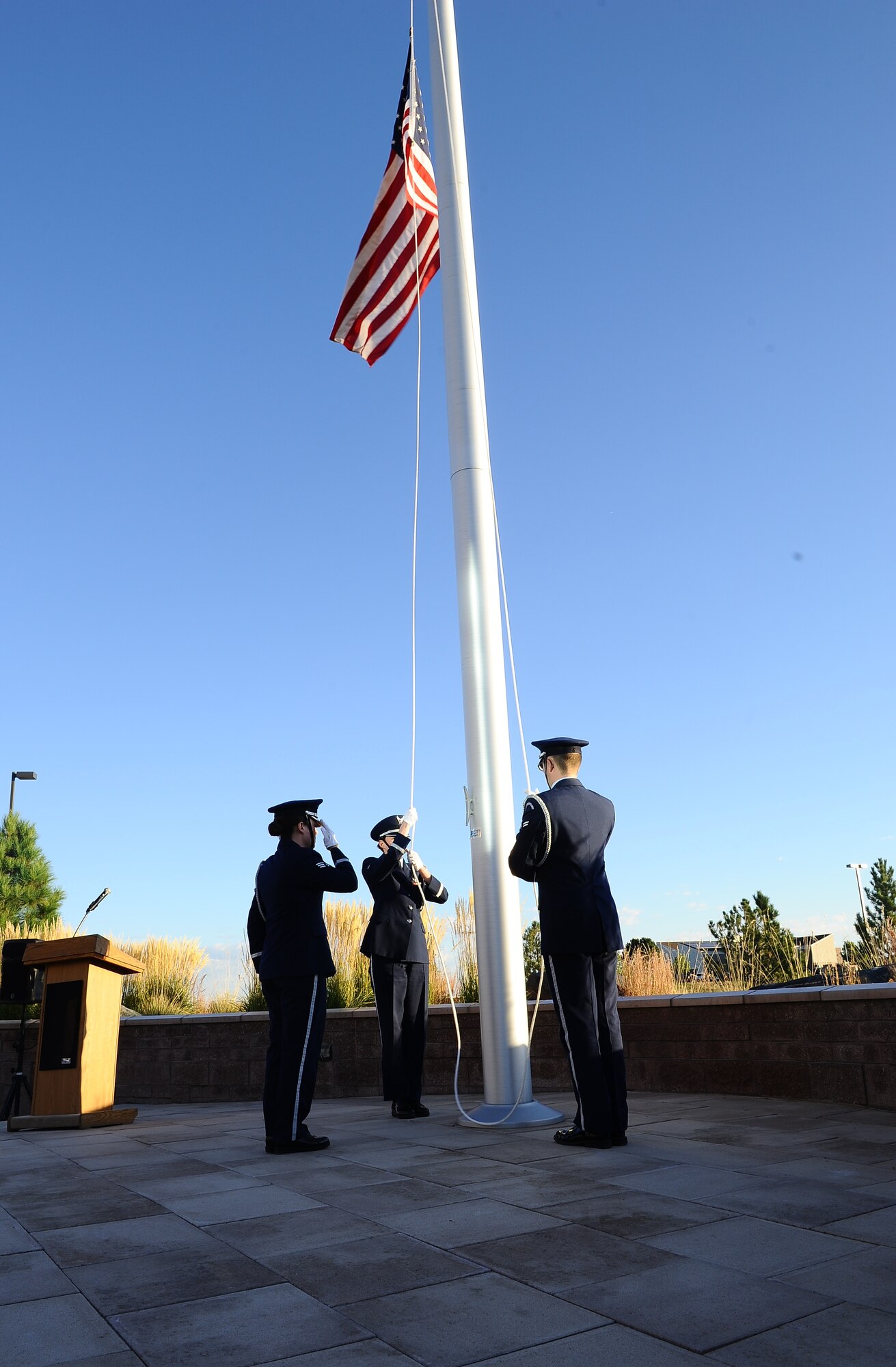 Mile High Honor Guard members lower the American flag to half-staff during the POW/MIA reveille ceremony Sept. 19, 2014, at the 460th Space Wing headquarters building on Buckley Air Force Base, Colo. According to the Defense Prisoner of War/Missing Personnel Office, more than 83,000 Americans are missing from World War II, the Korean War, the Cold War, the Vietnam War and the 1991 Gulf War. (U.S. Air Force photo by Tech. Sgt. Rob Hazelett/Released)