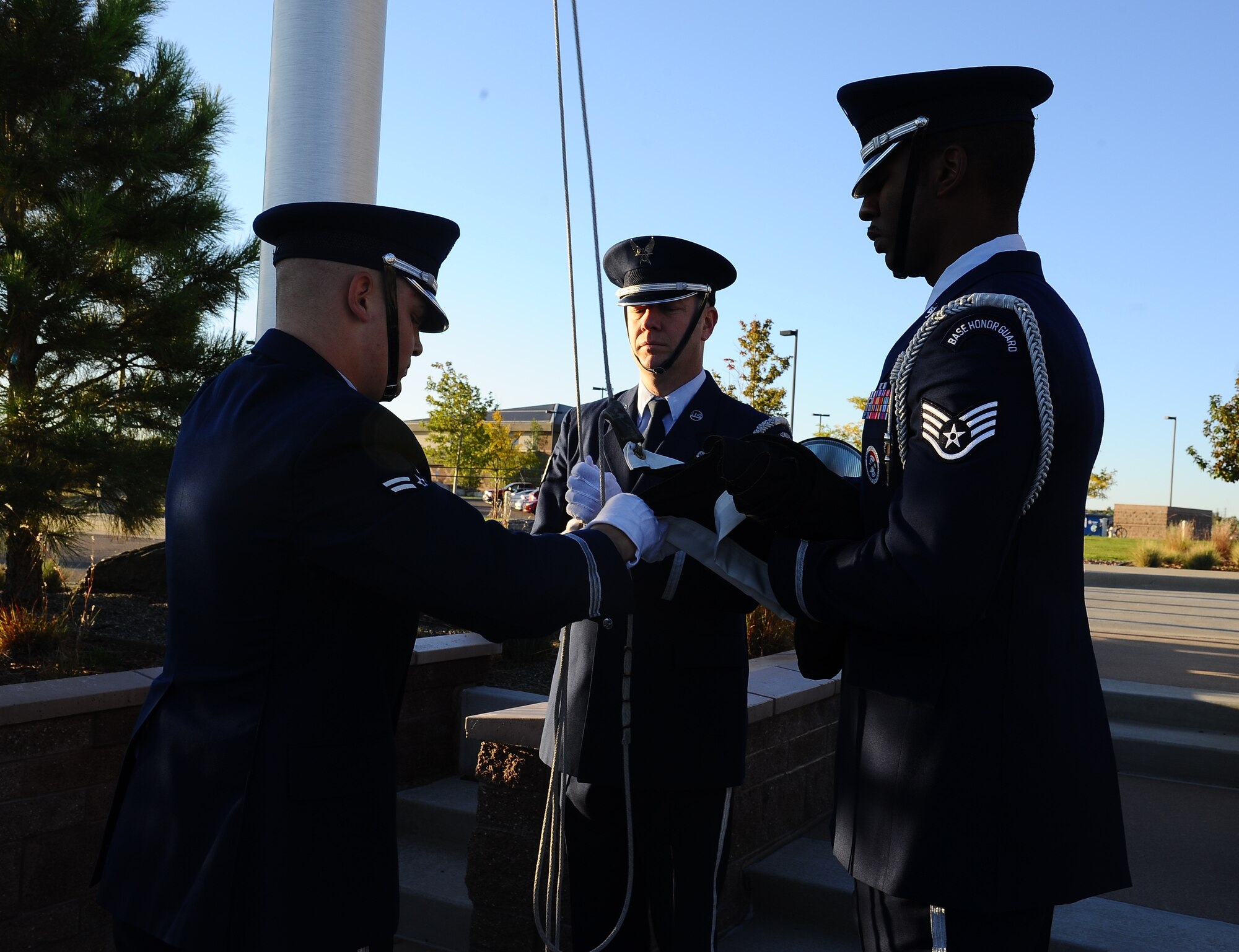 Mile High Honor Guard members prepare to raise the POW/MIA flag during the POW/MIA reveille ceremony Sept. 19, 2014, at the 460th Space Wing headquarters building on Buckley Air Force Base, Colo. National POW/MIA Recognition Day is traditionally observed around the world on military installations and ships, and in state capitals, schools and veterans' facilities on the third Friday in September each year. (U.S. Air Force photo by Tech. Sgt. Rob Hazelett/Released)