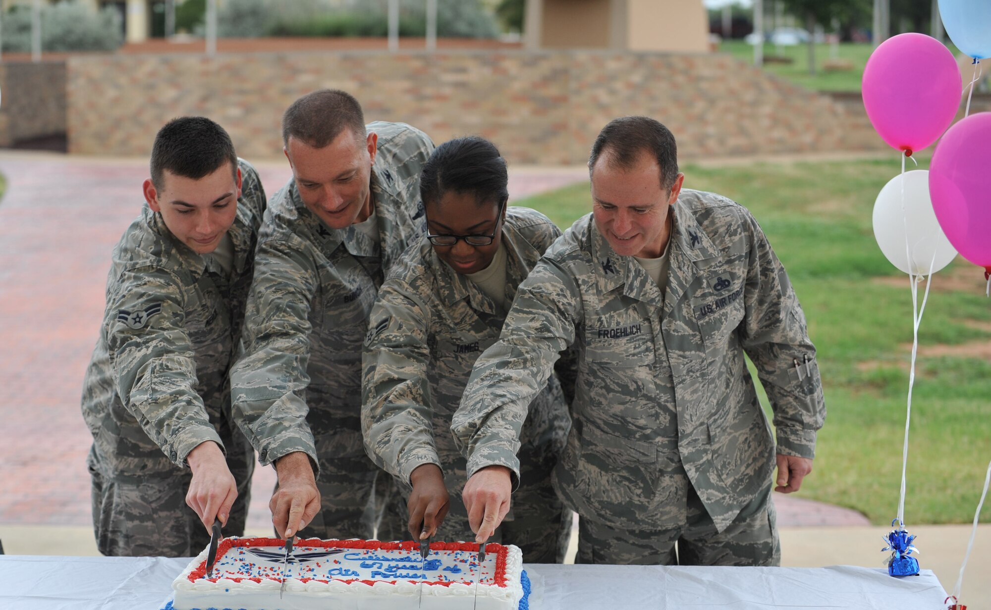 Col. Eric Froehlich, 82nd Training Wing vice commander, and Col. Lance Bunch, 80th Flying Training Wing commander, alongside the two youngest Airmen from both training wings cut the cake for the Air Force’s 67th birthday Sept. 18, 2014, Sheppard Air Force Base, Texas. The Rising 6 hosted a cookout style lunch and grilled hundreds of hotdogs, provided flavored shaved ice and a birthday cake for the celebration of a 67-year heritage. (U.S. Air Force photo/Airman 1st Class Robert L. McIlrath)

