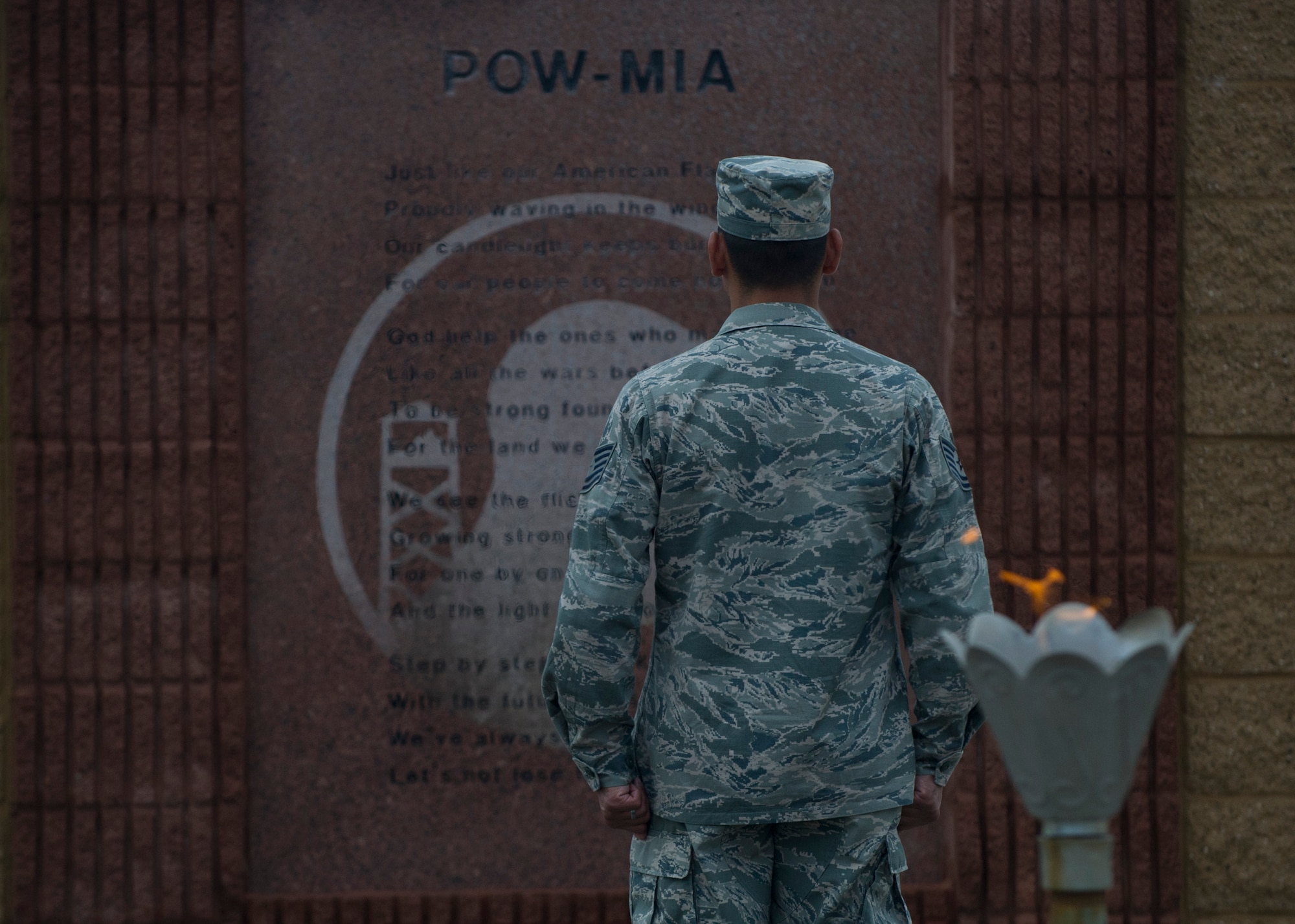 Despite the rainy New Mexico weather conditions, Technical Sgt. Giancarlo Reyes, 49th Materiel Maintenance Squadron electrical power production, stands at attention during Prisoner of War, Missing in Action Day of Remembrance at Holloman Air Force Base, N.M., Sept. 19.  Members of Team Holloman paid their respects during the Day of Remembrance by taking shifts with the POW/MIA flag, running a total of 24 hours, and standing a 24-hour guard at the POW/MIA memorial in Heritage Park. “We need to always remember the sacrifices of those that have gone before us,” said Col. Robert Kiebler, 49th Wing commander. “We will never forget, and we will never rest until all of those accounted for are returned home.” (U.S. Air Force photo by Senior Airman Leah Ferrante/Released)