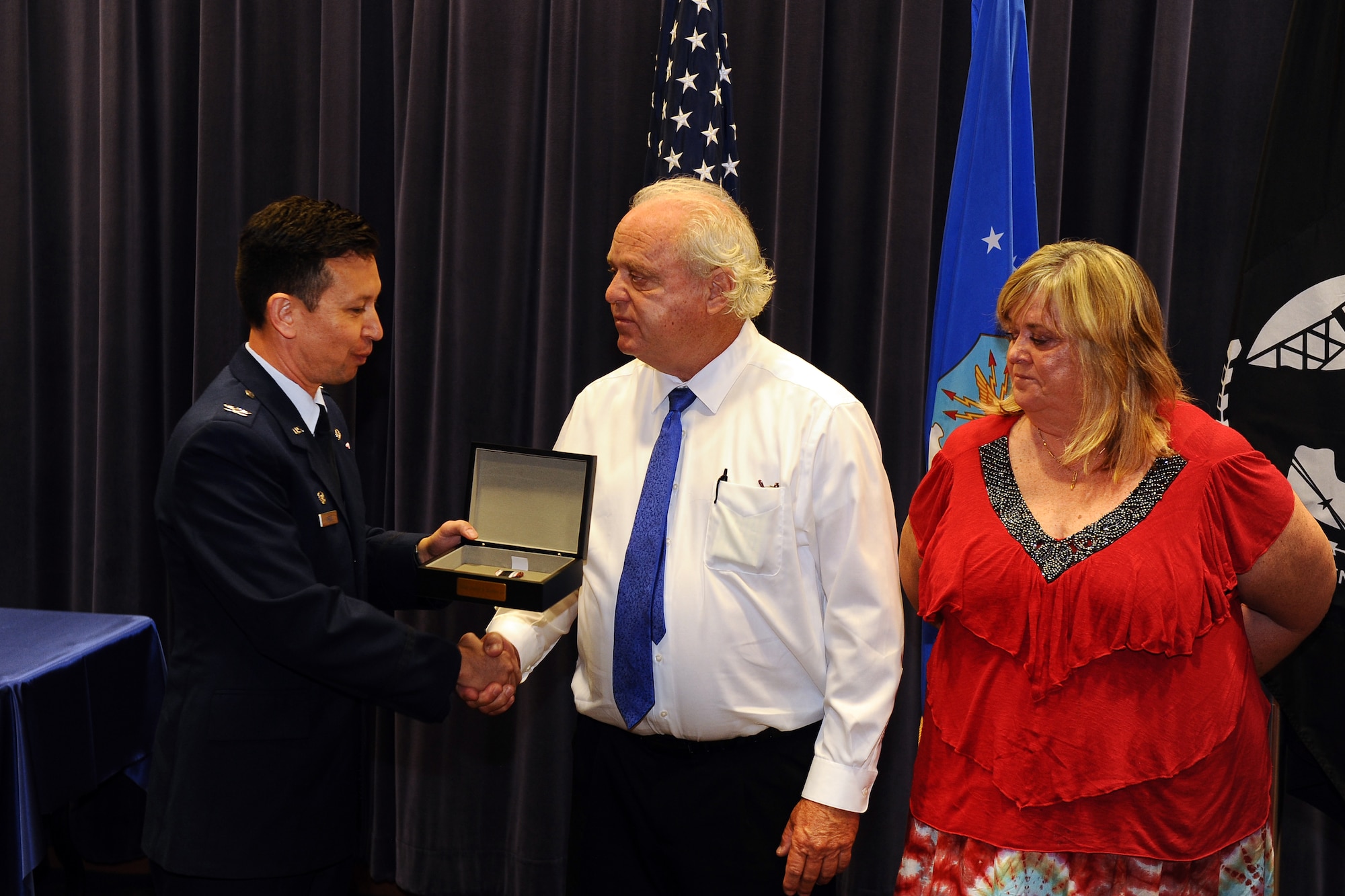 U.S. Air Force Col. William J. Carle, Air Force Weather Agency commander, presents the son and daughter of Capt. Dewey Keithly Jr., a WWII prisoner of war, with a Prisoner of War Medal during the AFWA POW/MIA ceremony Sept. 19. Keithly was released at the end of the war and returned home safely. He reenlisted and lost his life during the Korean War.  (U.S. Air Force photo by Josh Plueger)