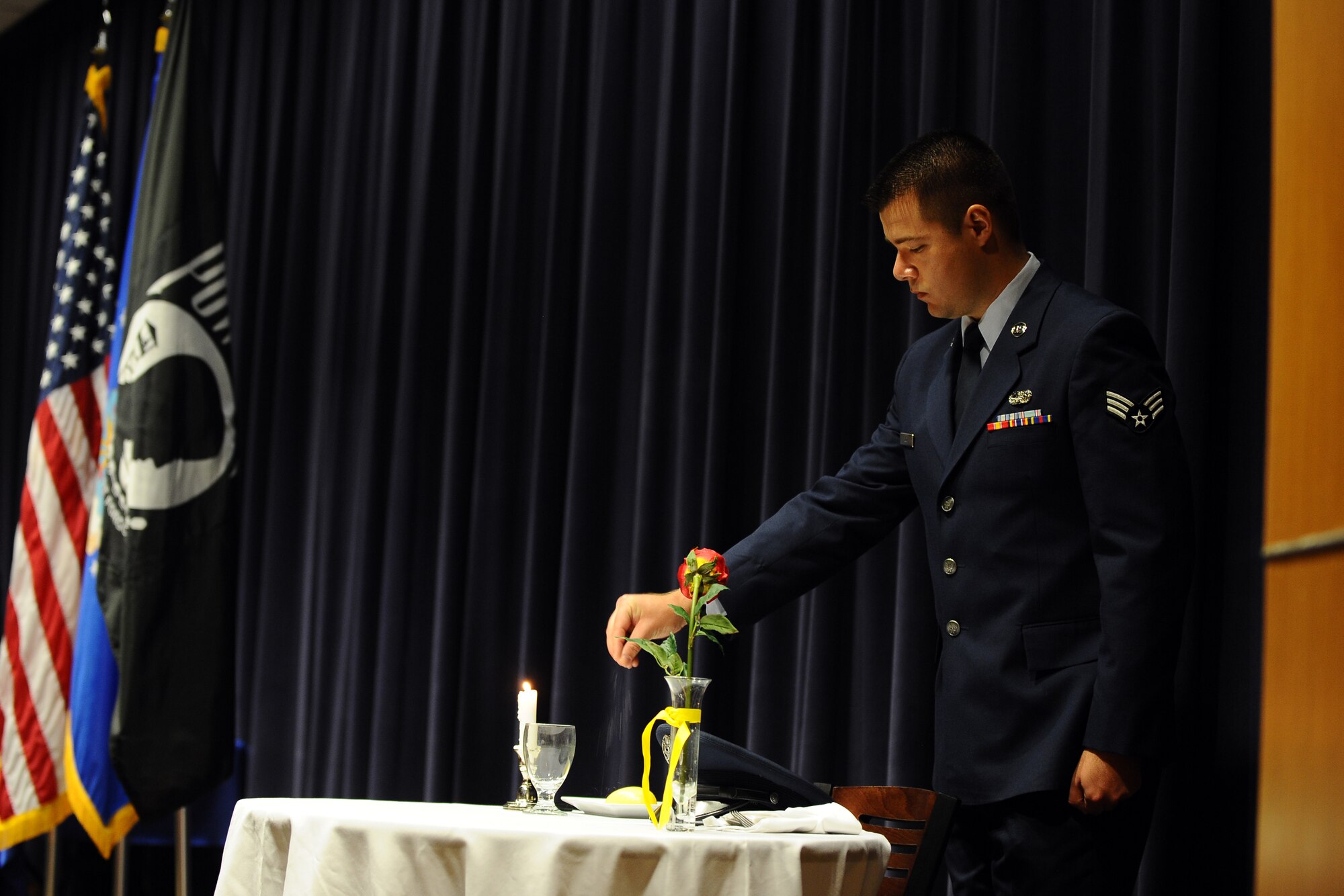 U.S. Air Force Senior Airman Christopher Luce, Air Force Weather Agency fielded systems supprt jounreyman, drops a pinch of salt, during the AFWA Prisoner of War/Missing in Action ceremony Sept. 19 in the AFWA auditorioum. The POW/MIA table ceremony recgnizes POW/MIAs from past and present wars.  (U.S. Air Force photo by Josh Plueger)