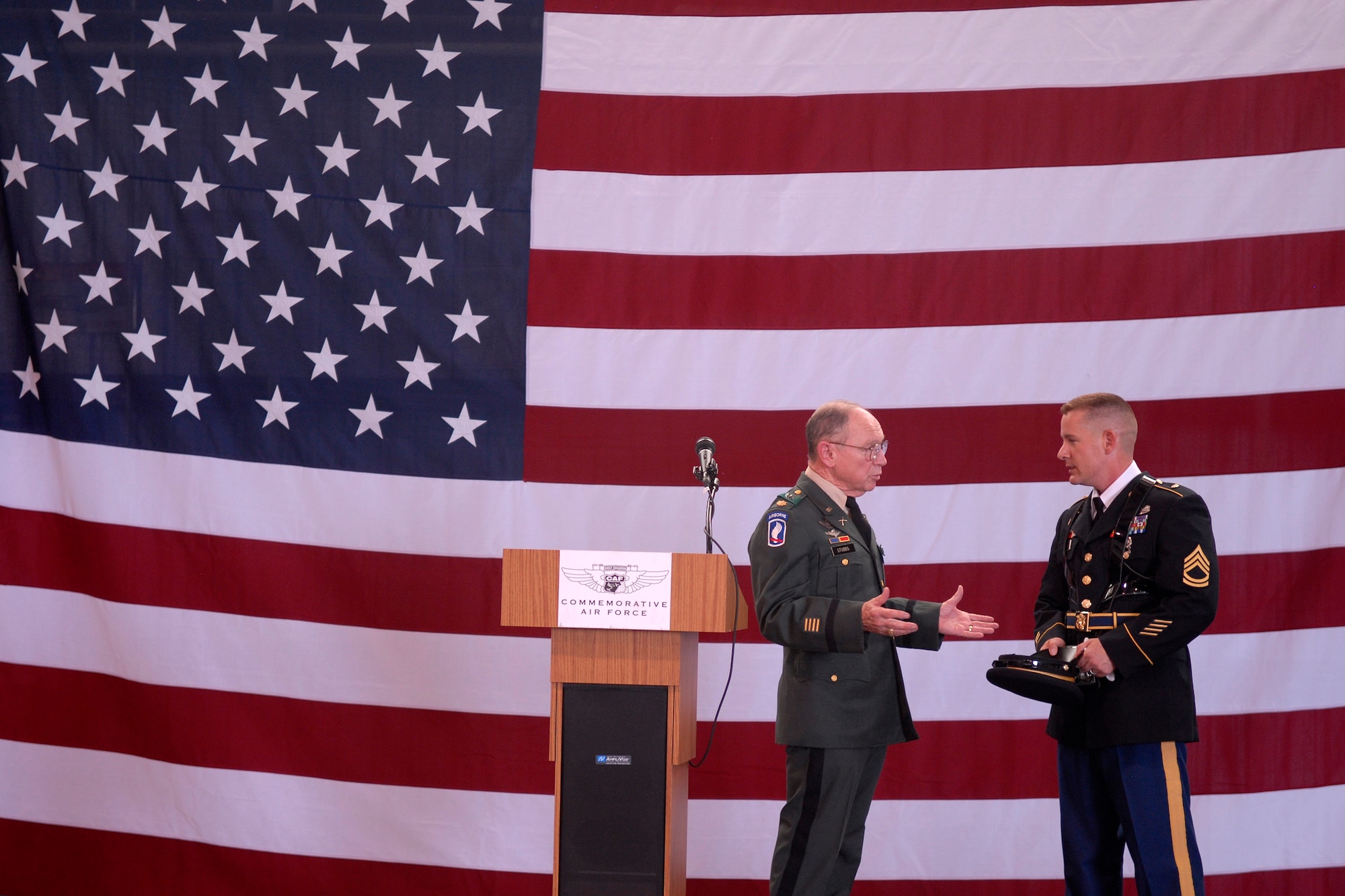 MIDLAND, Texas-- Retired Army Major Fred Stubbs and Sgt. 1st Class Eric M. Murray,344th Military Intelligence Battalion language course supervisor, converse onstage at the Bush Hangar in Midland before a dinner and ceremony honoring the veterans visiting Washington, D.C. Sept. 16. The Goodfellow Joint Service Color Guard presented the colors for the ceremony and at the sendoff the next day. (U.S. Air Force photo/ 1st Lt. Nathaniel Roesler)