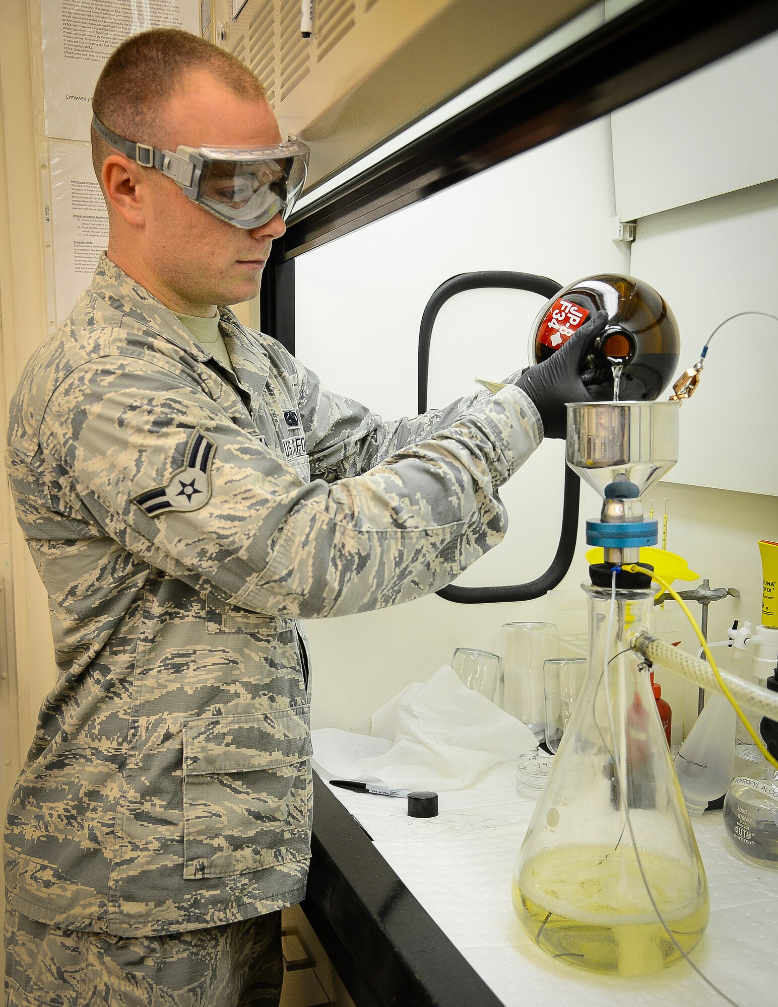 Airman 1st Class Corey Franklin, 6th Logistics Readiness Squadron fuels laboratory technician, pours a fuel sample through a filter pad to determine the amount of particulate contamination at MacDill Air Force Base, Fla., Sept. 18, 2014. Franklin is currently the only fuels laboratory technician working in MacDill’s fuels lab. (U.S. Air Force photo by Airman 1st Class Ned T. Johnston/Released)