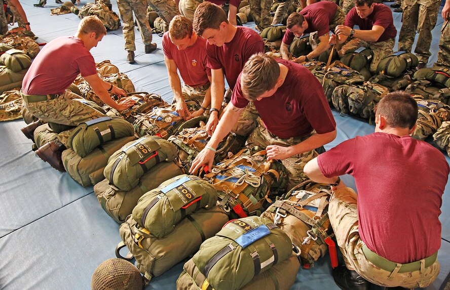 Members of II Squadron, Royal Air Force Regiment, perform an equipment check before a combat equipment jump on Sept. 11at RAF Brize Norton, England. II Squadron is the only airborne squadron in the RAF Regiment. It is their tradition to wear maroon shirt during their jumps. (Royal Air Force courtesy photo by Cpl. Barbara Robinson/Released)

