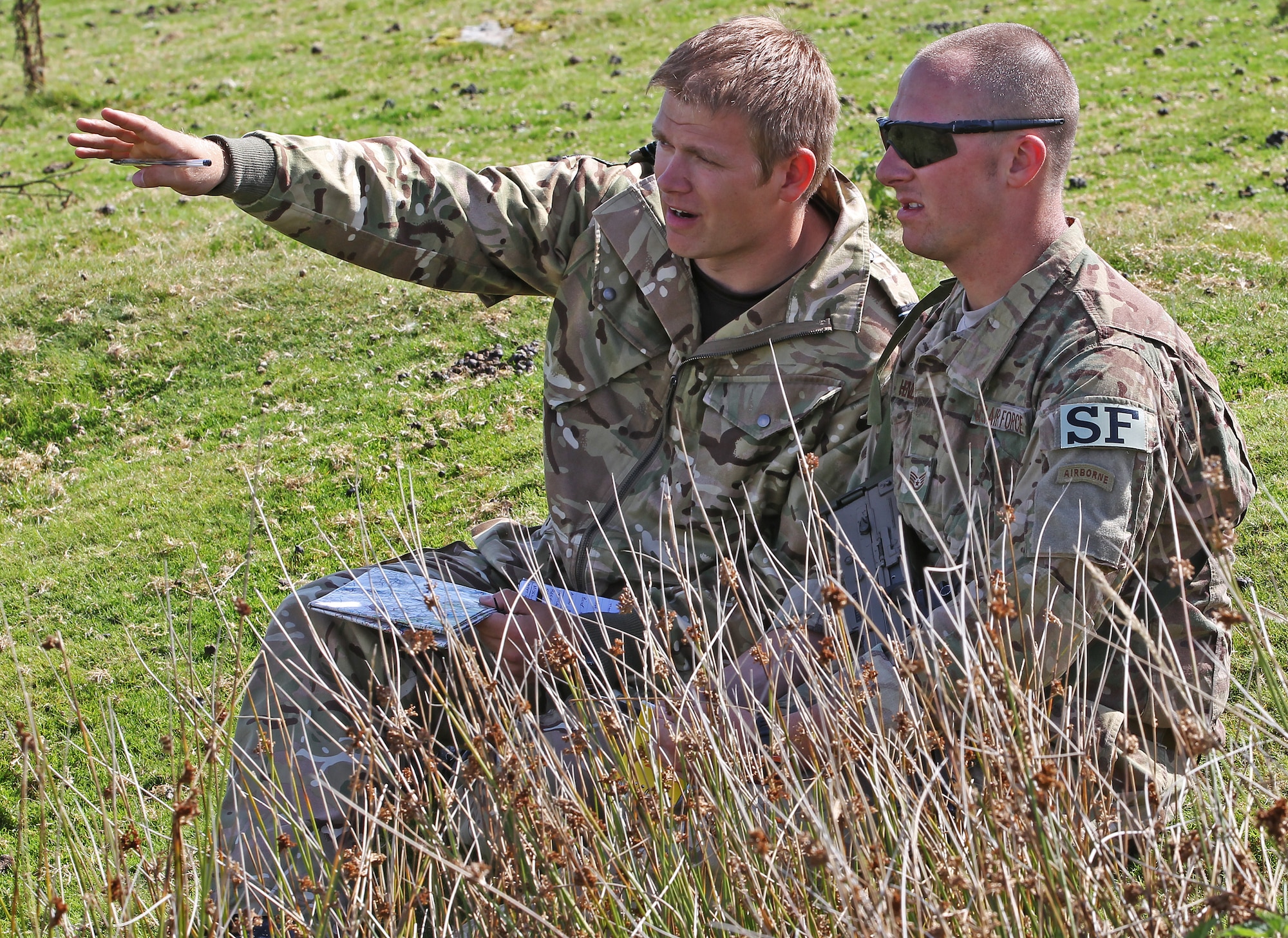 Flight Lt. Tom Smith, II Squadron, Royal Air Force Regiment, gives a situation brief to Staff Sgt. Kyle Henderson, 823rd Base Defense Squadron, during an assault course on Sennybridge Training Area, Wales, Sept. 8. The assault course was part of a military skills competition, the second phase of Exercise Global Eagle – a tri-nation combined exercise among the 820th Base Defense Group, RAF Regiment and Parachutiste De l’Air. The exercise enabled force protection specialists from three different nations to learn from each other and expand their defense capabilities. (Royal Air Force courtesy photo by Cpl. Barbara Robinson/Released)