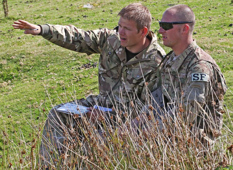 Flight Lt. Tom Smith, II Squadron, Royal Air Force Regiment, gives a situation brief to Staff Sgt. Kyle Henderson, 823rd Base Defense Squadron, during an assault course on Sennybridge Training Area, Wales, Sept. 8. The assault course was part of a military skills competition, the second phase of Exercise Global Eagle – a tri-nation combined exercise among the 820th Base Defense Group, RAF Regiment and Parachutiste De l’Air. The exercise enabled force protection specialists from three different nations to learn from each other and expand their defense capabilities. (Royal Air Force courtesy photo by Cpl. Barbara Robinson/Released)