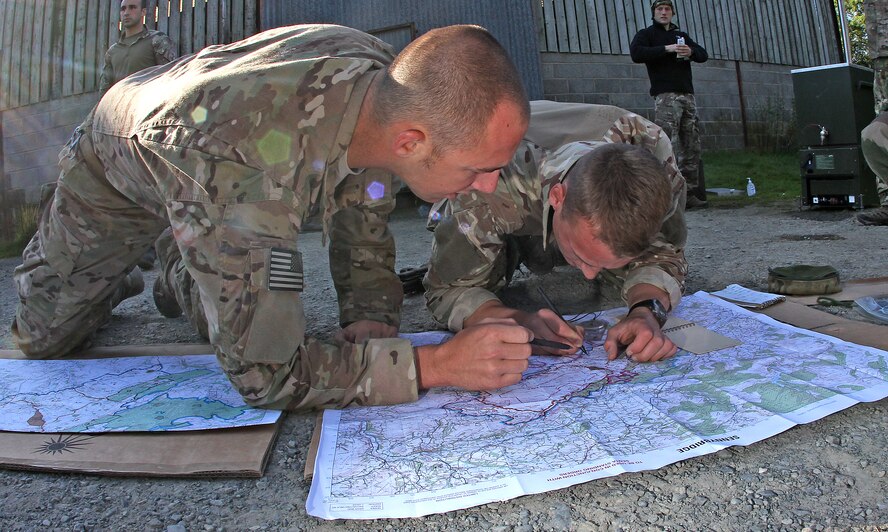 Force protection specialists from the 823rd Base Defense Squadron and II Squadron map out a course for a land navigation training operation at Sennybridge Training Area,Wales, Sept. 8. The second phase of Operation Global Eagle, the military skills phase, included a 15-hour land navigation course. (Royal Air Force courtesy photo by Cpl. Barbara Robinson/Released)