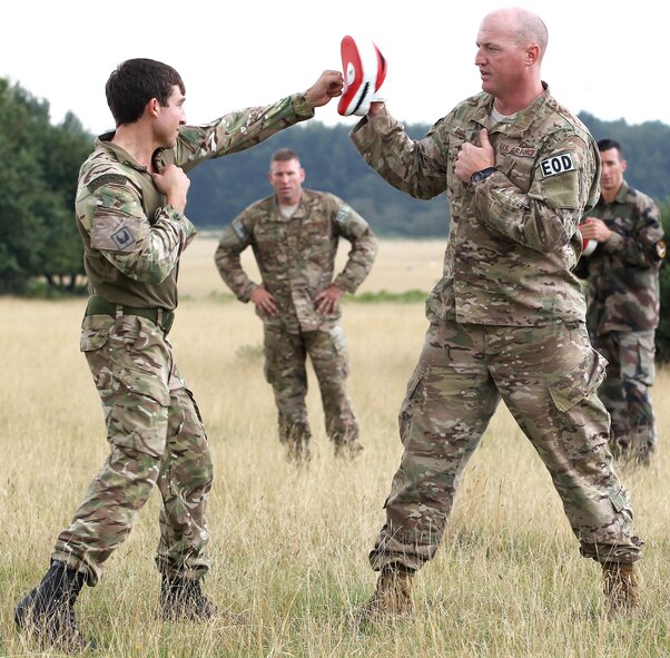 Technical Sgt. Lee Fulp, an explosive ordnance disposal technician assigned to the 820th Base Defense Group, practices hand-to-hand combat with Senior Aircraftsman Daniel Lythgoe, Royal Air Force Regiment, while Master Sergeant Justin Greers, 823rd Base Defense Squadron, evaluates on Sept. 2 at Stanford Training Range, England. During this phase of Exercise Global Eagle, Airmen from the 820th ABG instructed their French and British counterparts on combative principles, while the RAF taught a similar concept referred to as ‘section attack.’ (Royal Air Force courtesy photo by Cpl. Barbara Robinson/Released)
