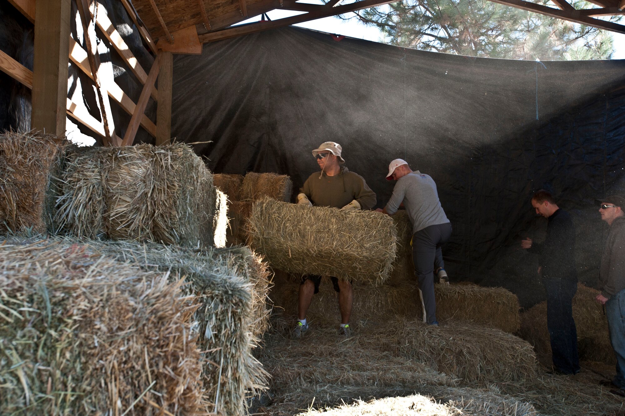 Fairchild Air Force Base Airmen gather together to assist in loading hay at Rocky Cove Youth Ranch in Tum Tum, Washington, Sept. 15, 2014. The ranch finds volunteers help prepare for their Healing Hearts through Horses program that allows children to learn and ride horses.  The ranch holds the program for troubled youth and foster children, allowing them to learn values that help foster growth and development.  (U.S. Air Force photo by Staff Sgt. Veronica Montes/Released)