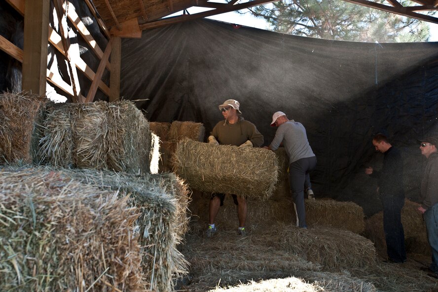 Fairchild Air Force Base Airmen gather together to assist in loading hay at Rocky Cove Youth Ranch in Tum Tum, Washington, Sept. 15, 2014. The ranch finds volunteers help prepare for their Healing Hearts through Horses program that allows children to learn and ride horses. The ranch holds the program for troubled youth and foster children, allowing them to learn values that help foster growth and development. (U.S. Air Force photo/Staff Sgt. Veronica Montes)