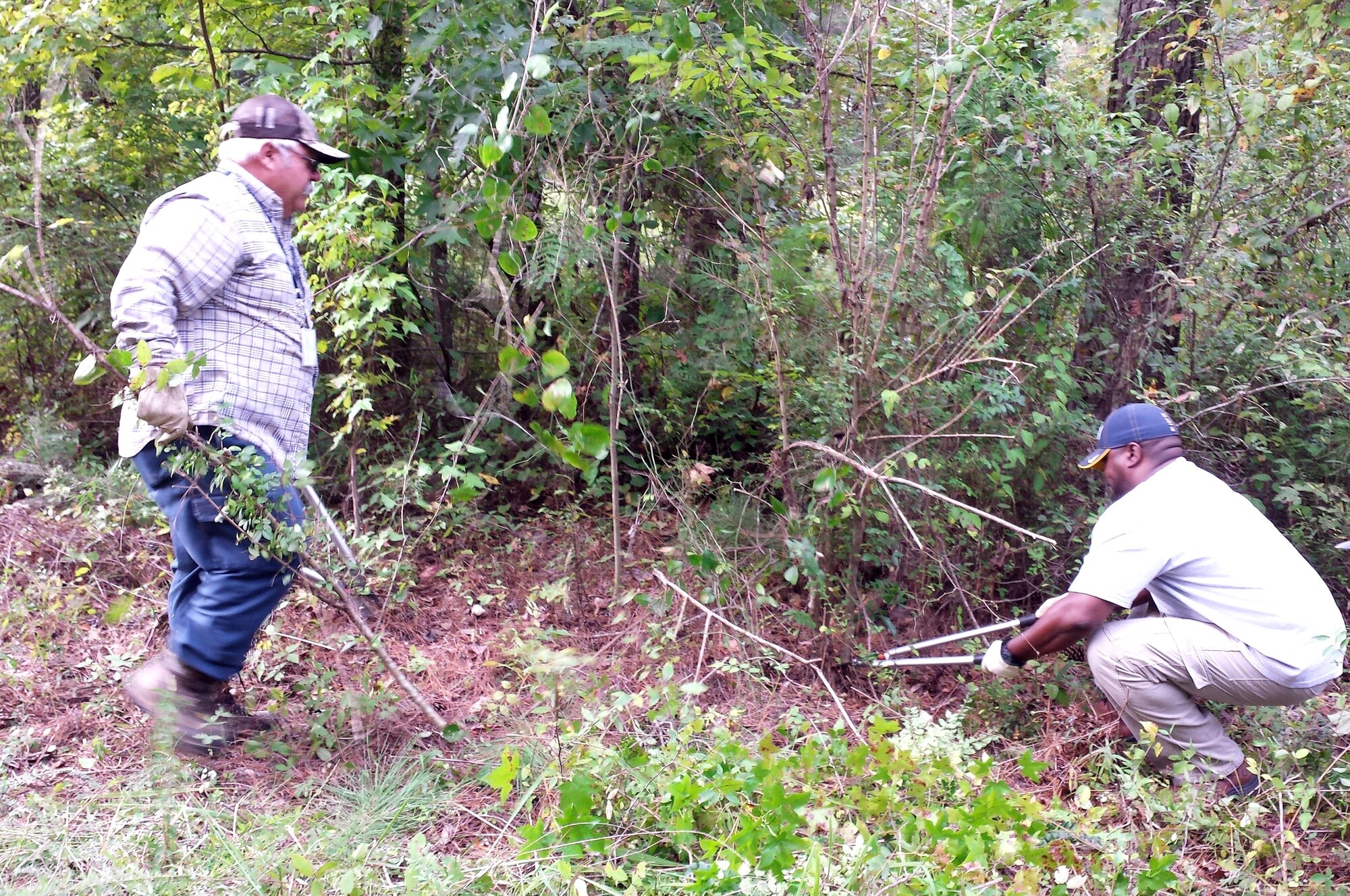 Bob Harmon and Jamal Lewis, 14th Civil Engineer Squadron, clear a picnic area of branches on the main nature trail. As part of Public Lands Day, volunteers from all over Columbus Air Force Base took part in the annual Nature Trail clean-up Sept. 15. (Courtesy Photo)