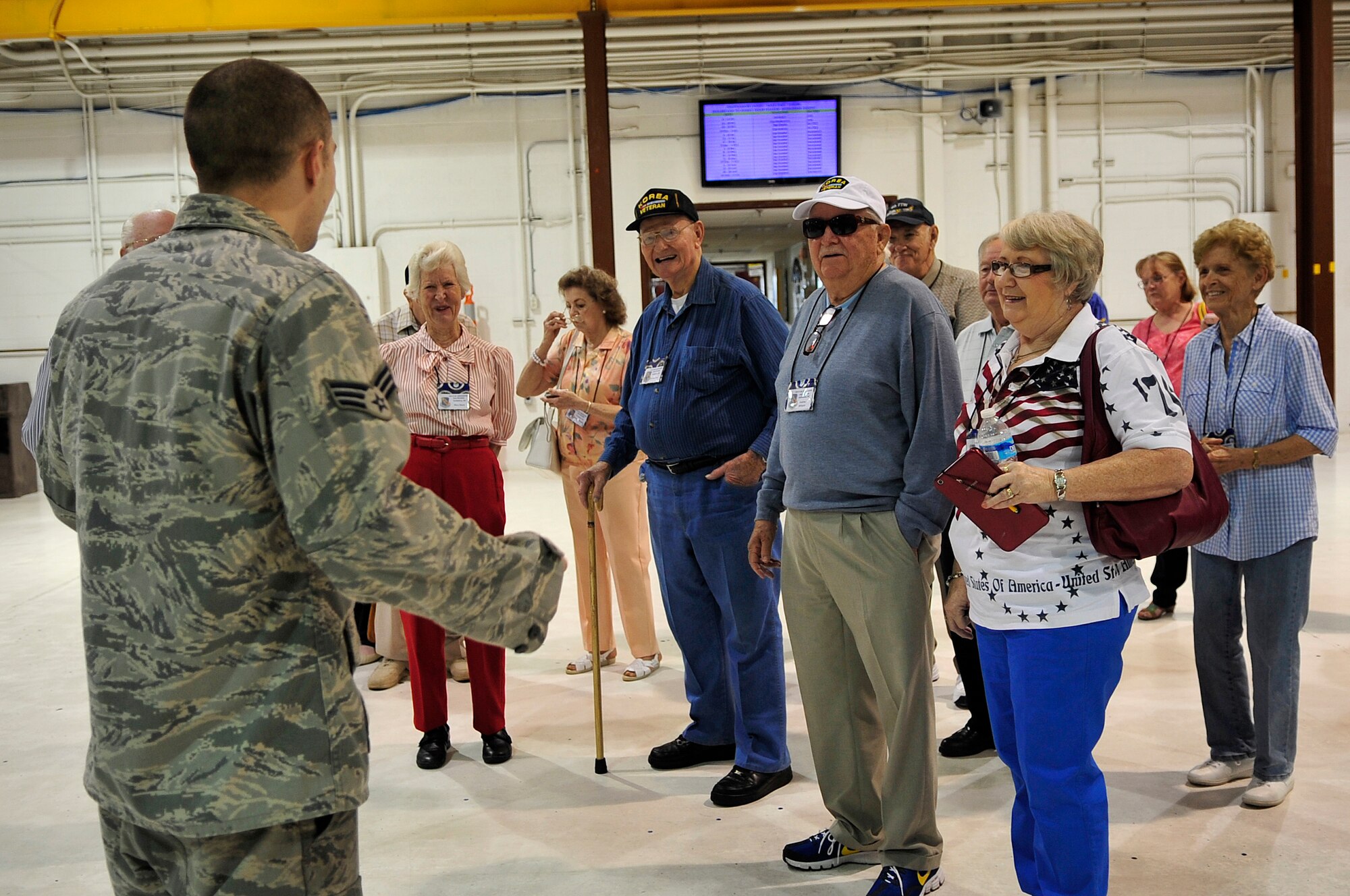 Senior Airman Russell White, 4th Component Maintenance Squadron propulsion flight, addresses a group of Korean War veterans and their families during the 4th Fighter Interceptor Wing reunion at Seymour Johnson Air Force Base, North Carolina Sept. 12. The veterans, who were assigned to the 4th FIW during the Korean War, toured much of the base and held several functions Sept. 11-13. (U.S. Air Force photo/Airman 1st Class Shawna Keyes)