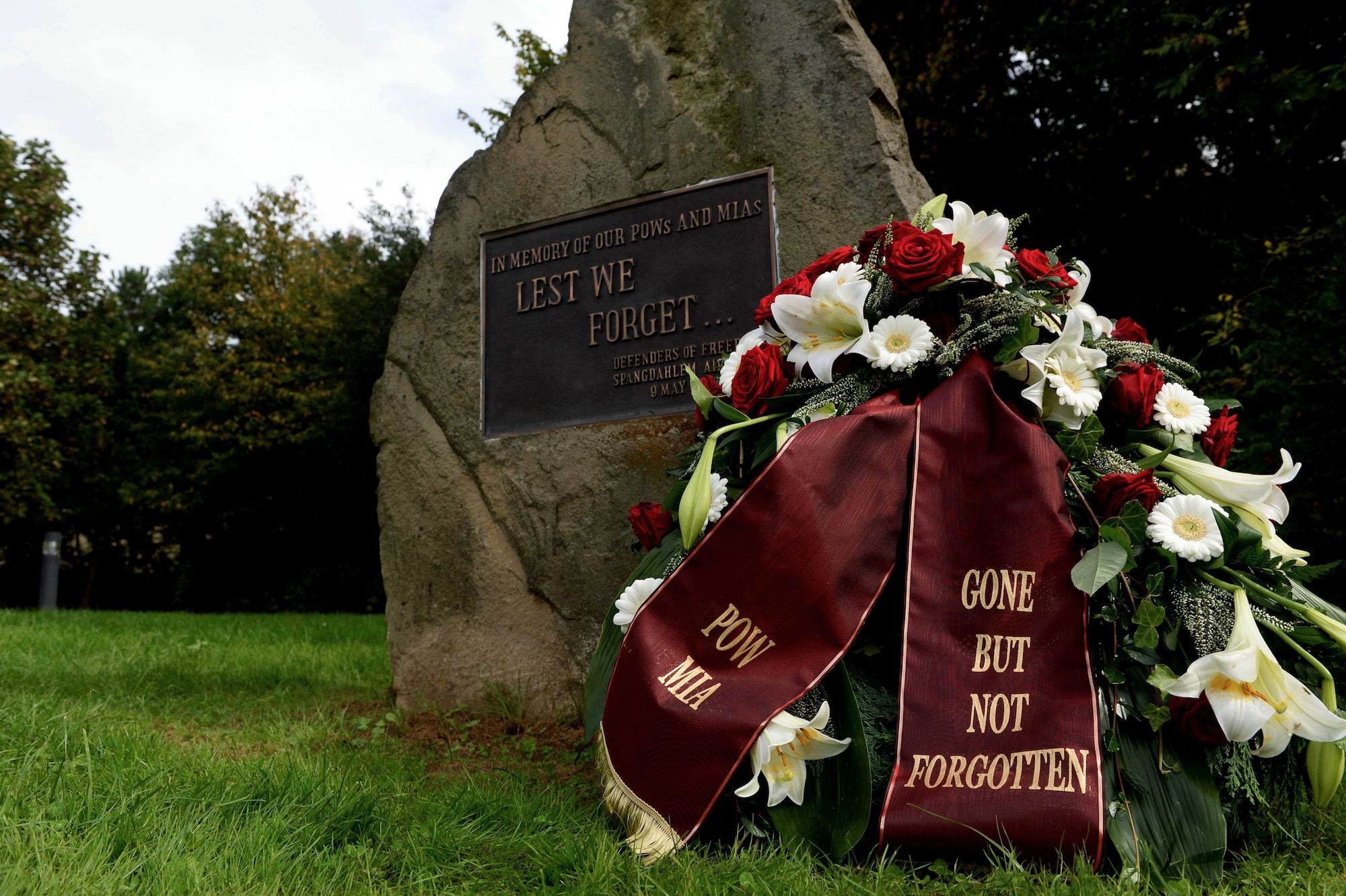 The POW/MIA wreath rests on a POW/MIA memorial rock during the ceremony at the Air Park on  Spangdahlem Air Base, Germany, Sept. 19, 2014. The wreath was placed next to the memorial in honor and remembrance of those who fought and were taken prisoners of war and missing in action. (U.S. Air Force photo by Airman 1st Class Timothy Kim/Released)