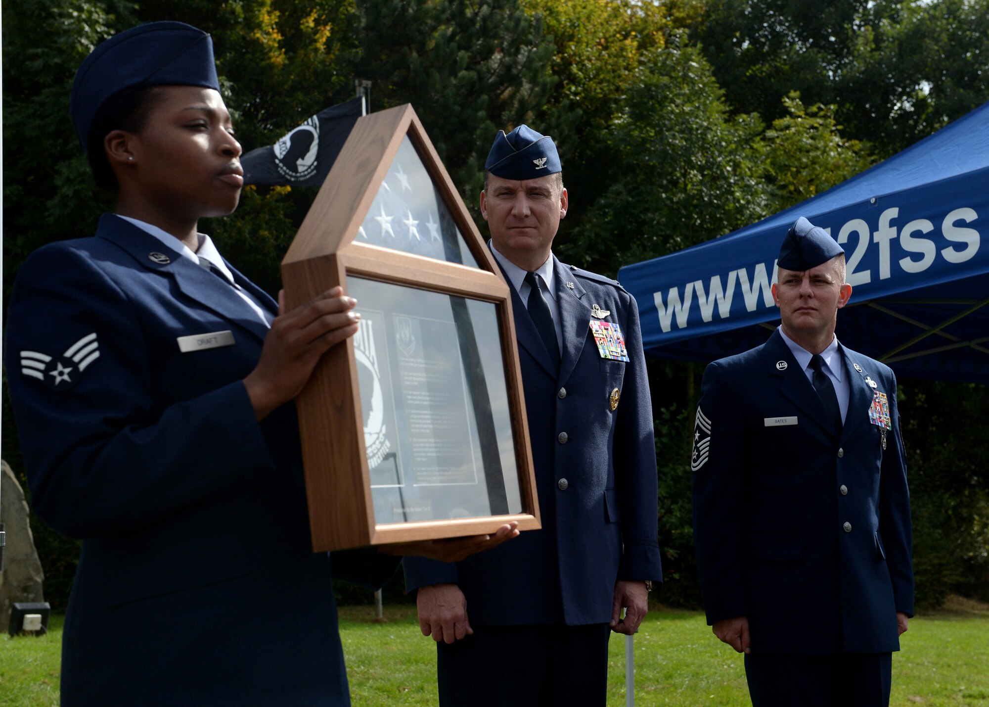 U.S. Air Force Col. Pete Bilodeau, 52nd Fighter Wing commander, and Chief Master Sgt. Brian Gates, 52nd Fighter Wing command chief, receive the shadow box during the POW/MIA ceremony at the Air Park on Spangdahlem Air Base, Germany, Sept. 19, 2014. The POW/MIA flag was designed as a symbol of concern for U.S. military personnel taken as prisoners or missing. (U.S. Air Force photo by Airman 1st Class Timothy Kim/Released)